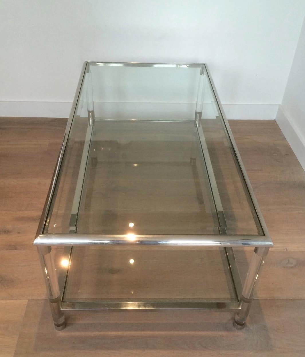 This large coffee table is made of chrome and Lucite with two glass shelves, beveled on top glass. This is a French design, circa 1970.