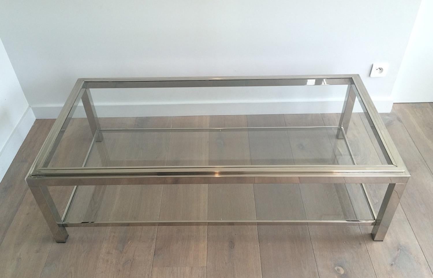 This large coffee table is made of chrome with two clear glass shelves. The quality of this cocktail table is very nice and the top glass is inserted in a chrome frame. This is a French work, circa 1970.