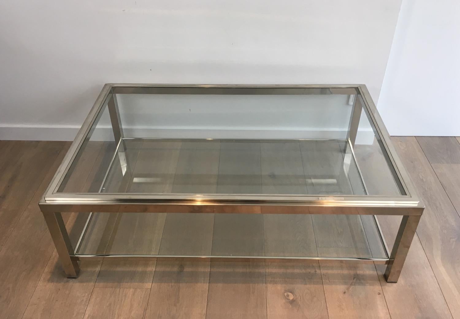 This very nice large coffee table is made of chrome with two clear glass shelves. The top glass is inserted in a chrome frame. This is a very nice French work, circa 1970.
