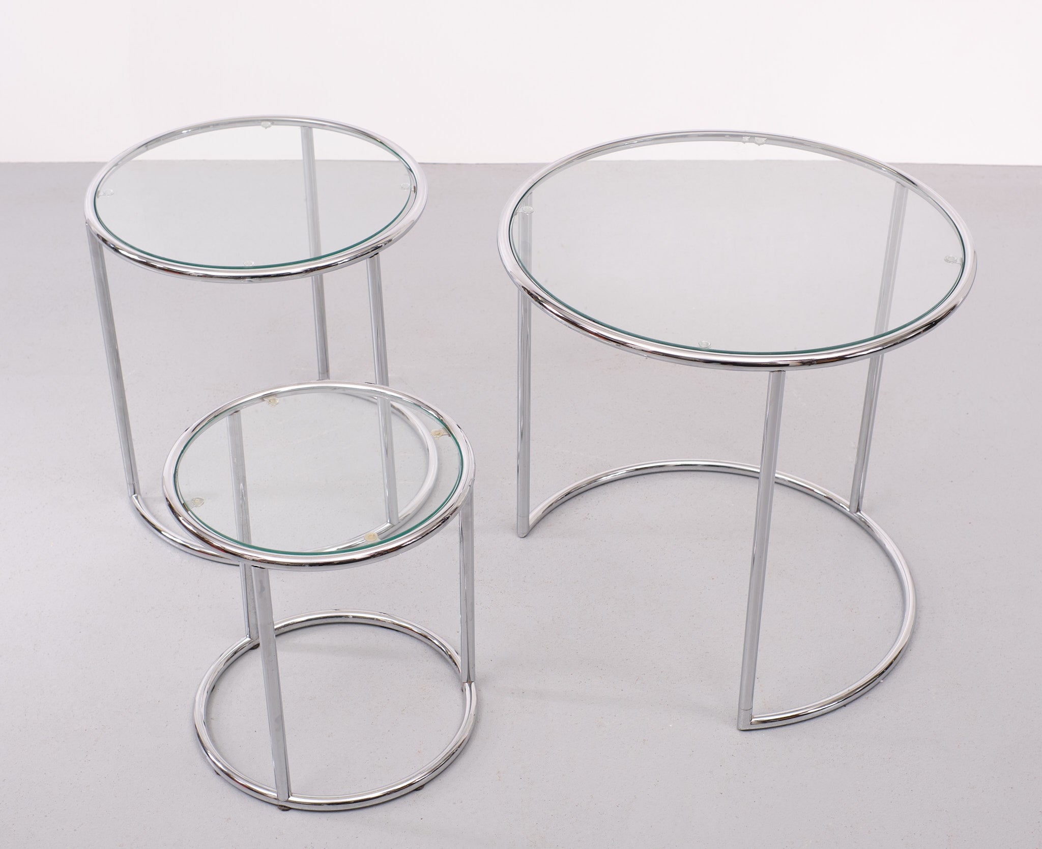 Very nice and unusual set of nesting table . Round shaped. larger then normal .
Chrome Metal frame ,comes with Glass tops . Easy and practical in use . 
The measurements are for the largest table .