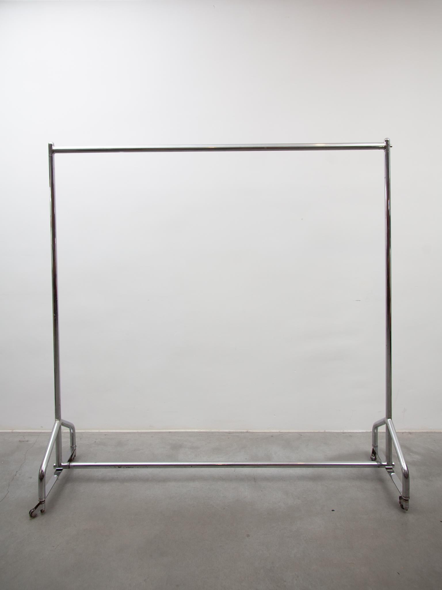 Very rare professional 1930s rolling clothing rack. A perfect rack for hanging your festive long evening dresses and coats. Cast iron and chrome finish standing on 4 covered wheels.In original good condition with some signs of use at rolling