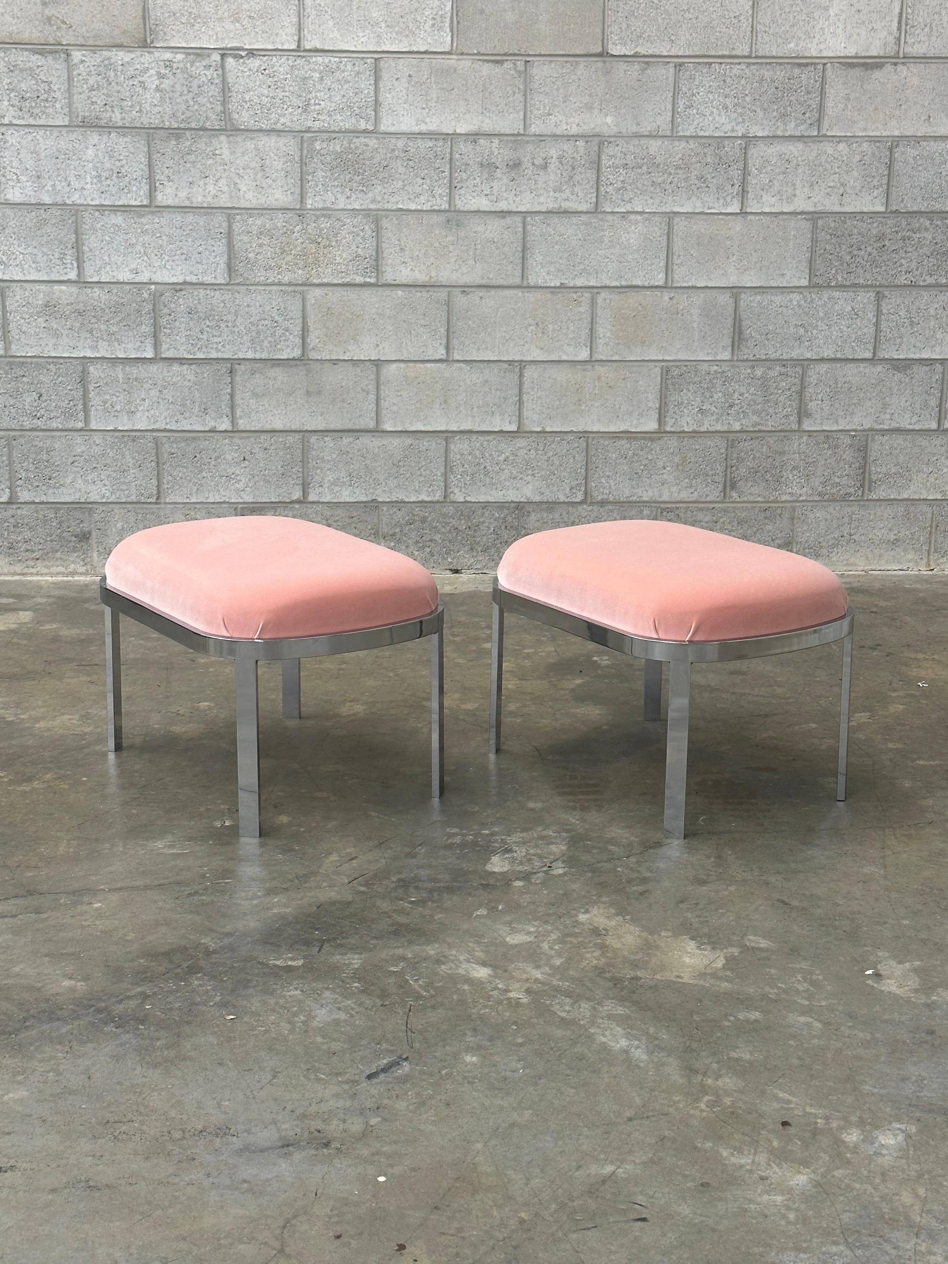 Pair of vintage chrome stools or ottomans in the style of Milo Baughman. Featuring well constructed, heavy gauge chromed steel frames, and newer upholstered seats in a beautiful blush pink velvet. These would be perfect as functional accent pieces