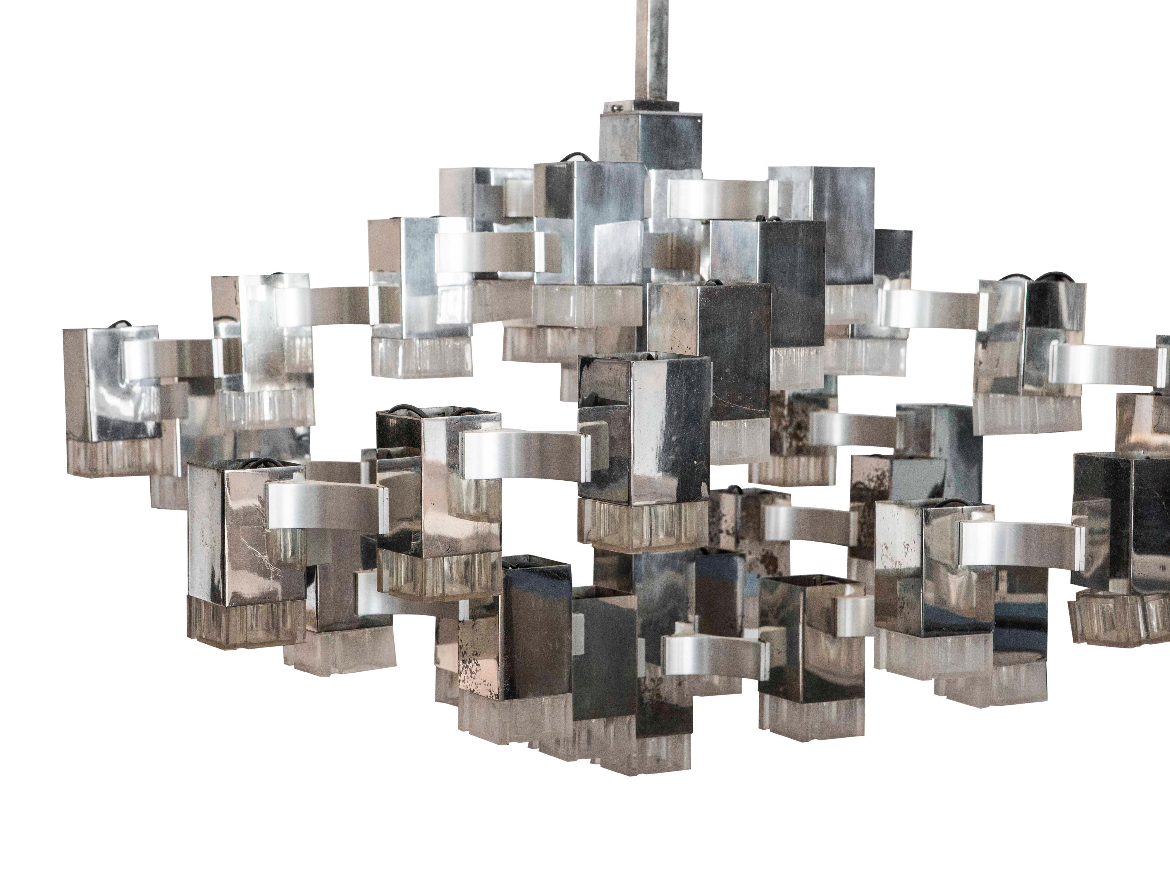A dramatic chromed steel and glass cubist chandelier by Gaetano Sciolari. The fixture is comprised of four (4) sections of conjoined cubes, emanating from a central steel rectangular stem. 36 lights, newly rewired for USA.