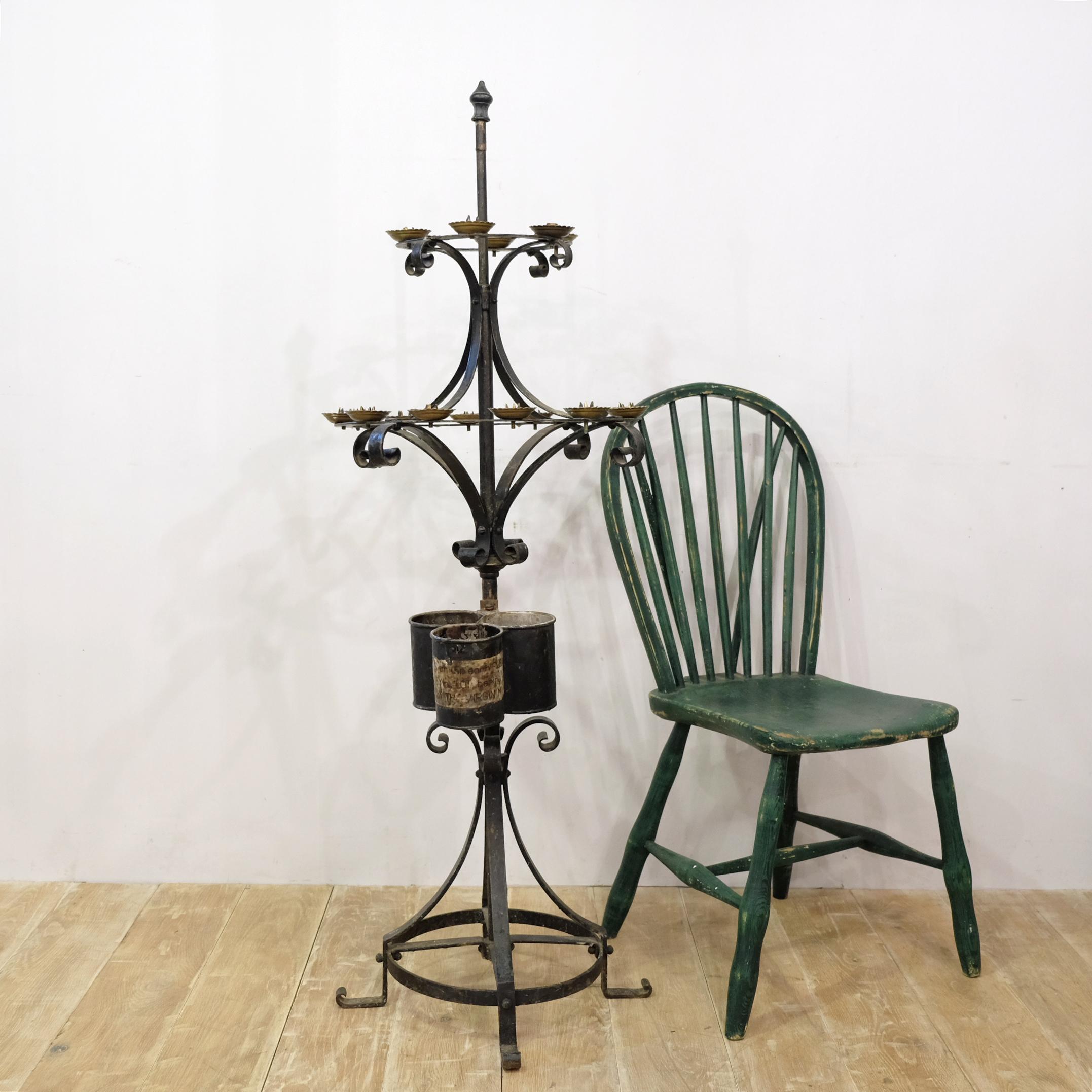 A large Victorian period wrought iron and brass votive stand. These are used in churches to hold candles that can be lit when offering a prayer. The lower section has three metal containers that would hold the unlit candles, one with a slightly