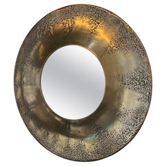 Large circular mirror with concave and textured brass surround