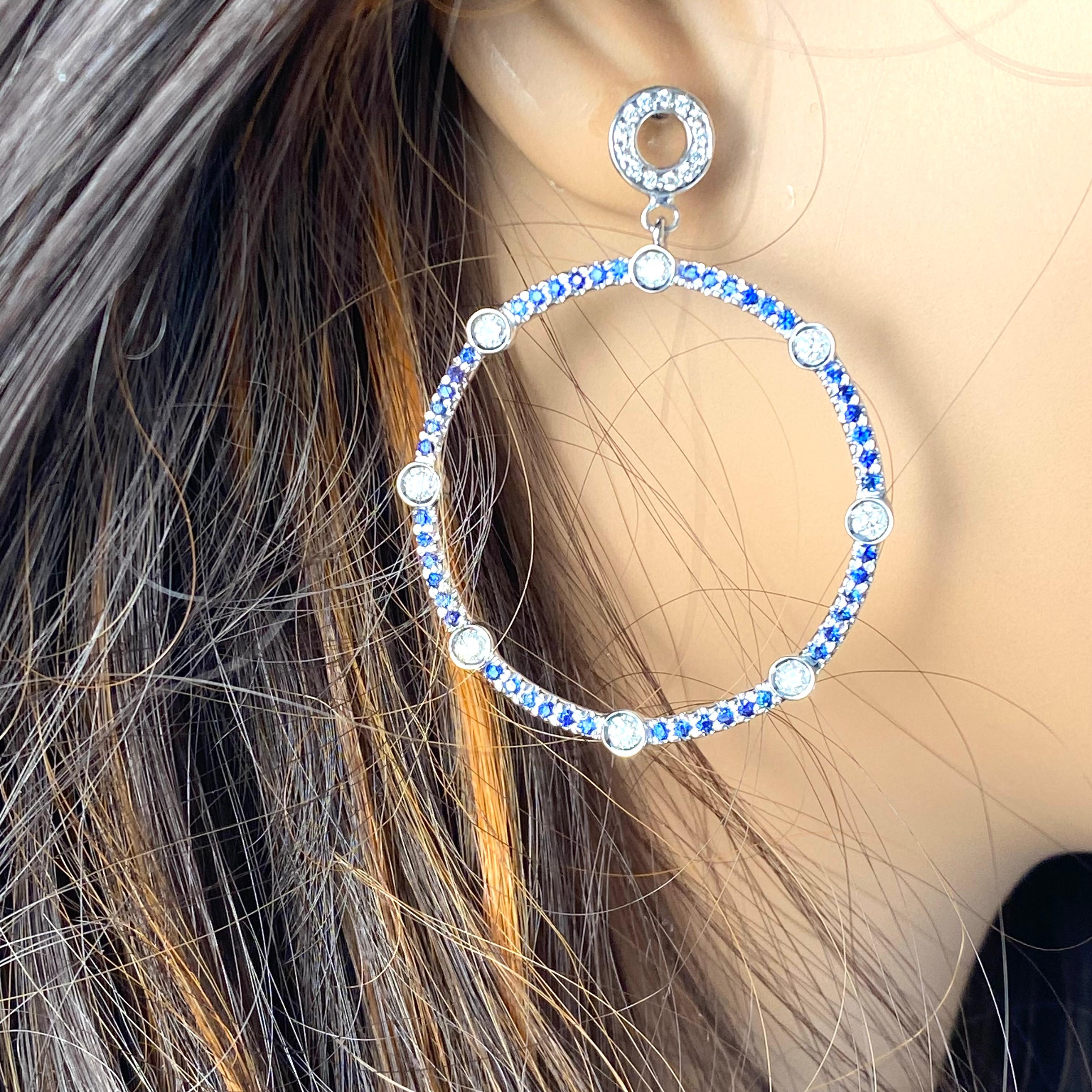 Wir stellen Ihnen unsere exquisiten großen runden Saphir- und Diamantohrringe vor, eine atemberaubende Verschmelzung von Eleganz und Raffinesse. Diese perfekt gearbeiteten Ohrringe bestechen durch ihr faszinierendes Design mit glänzenden Saphiren