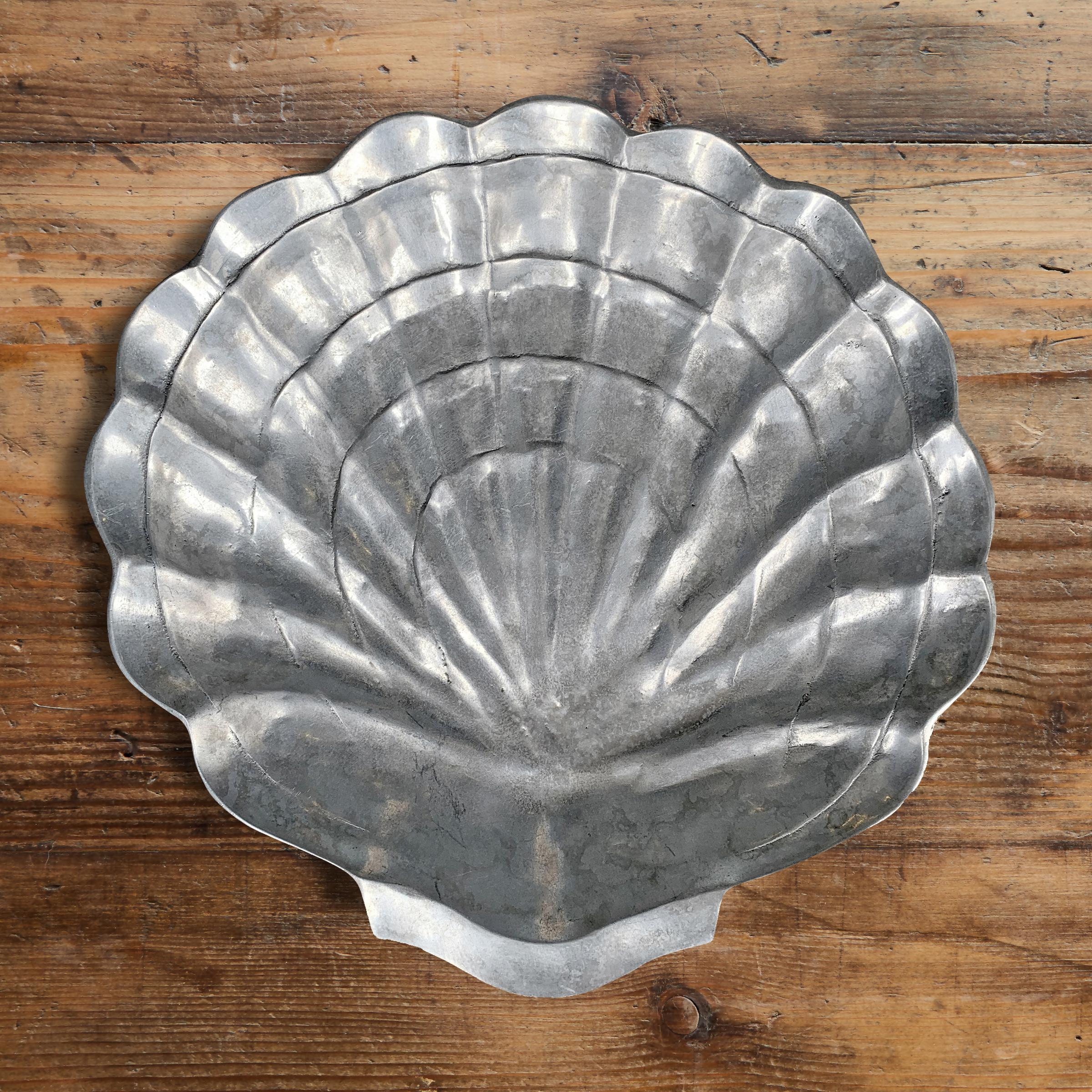 A rather large aluminum clam shell bowl, more than likely originally used for holding ice and serving oysters. It's wonderfully sculptural and perfect for holding things in your kitchen, or filled with chips at your next fête.