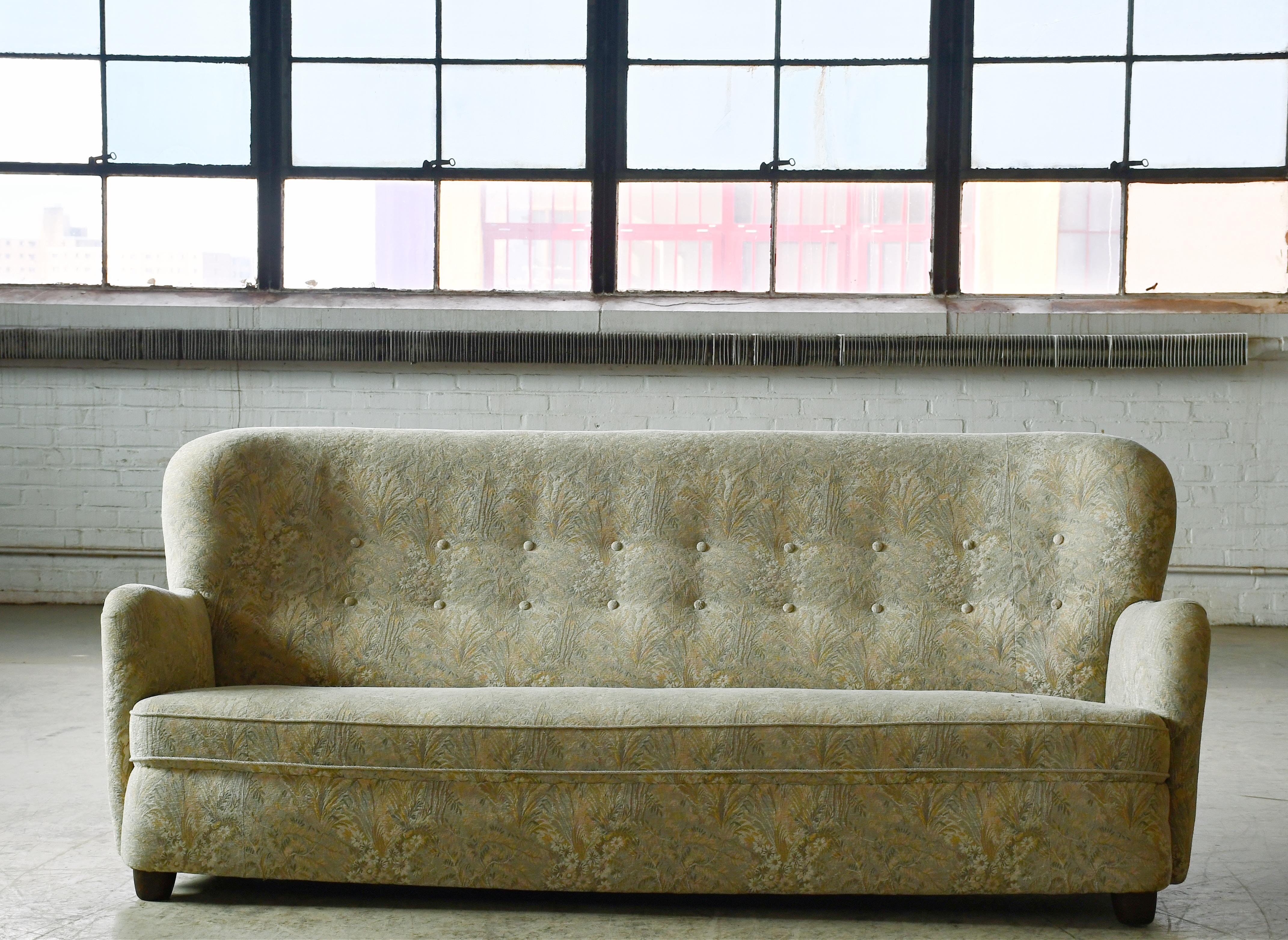 Precioso y muy elegante sofá danés de tres plazas de principios de los años 50. Sólida construcción con muelles en el asiento y el respaldo para apoyo y amortiguación. Diseño fresco con un respaldo ligeramente alto. Gran presencia con seductoras