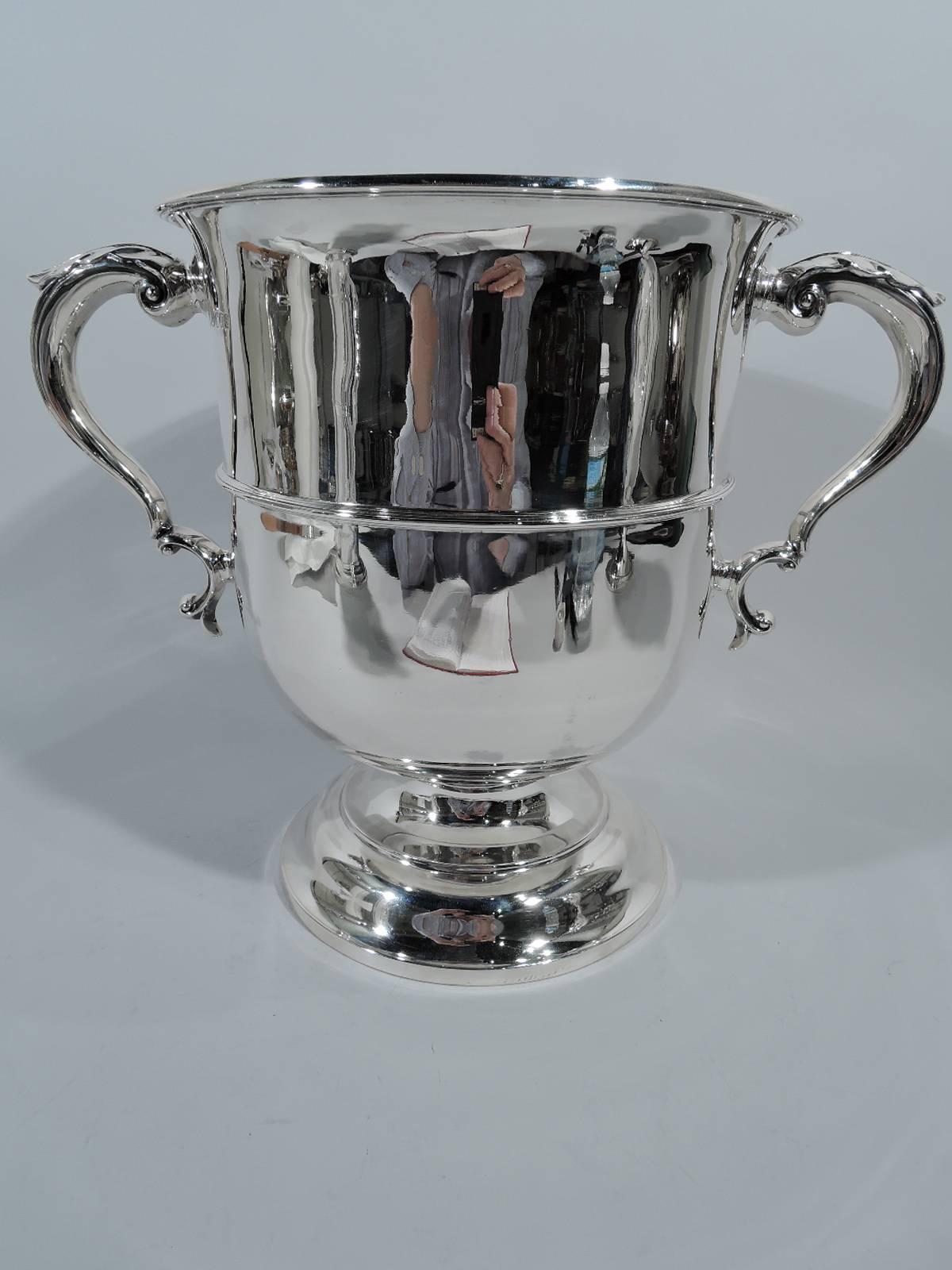 Edwardian sterling silver trophy cup. Made by Searle & Co. in London in 1904. Classic girdled urn with molded flared rim, stepped foot and leaf-capped double-scroll side handles. A beautiful first prize with lots of room for engraving. Hallmarked.