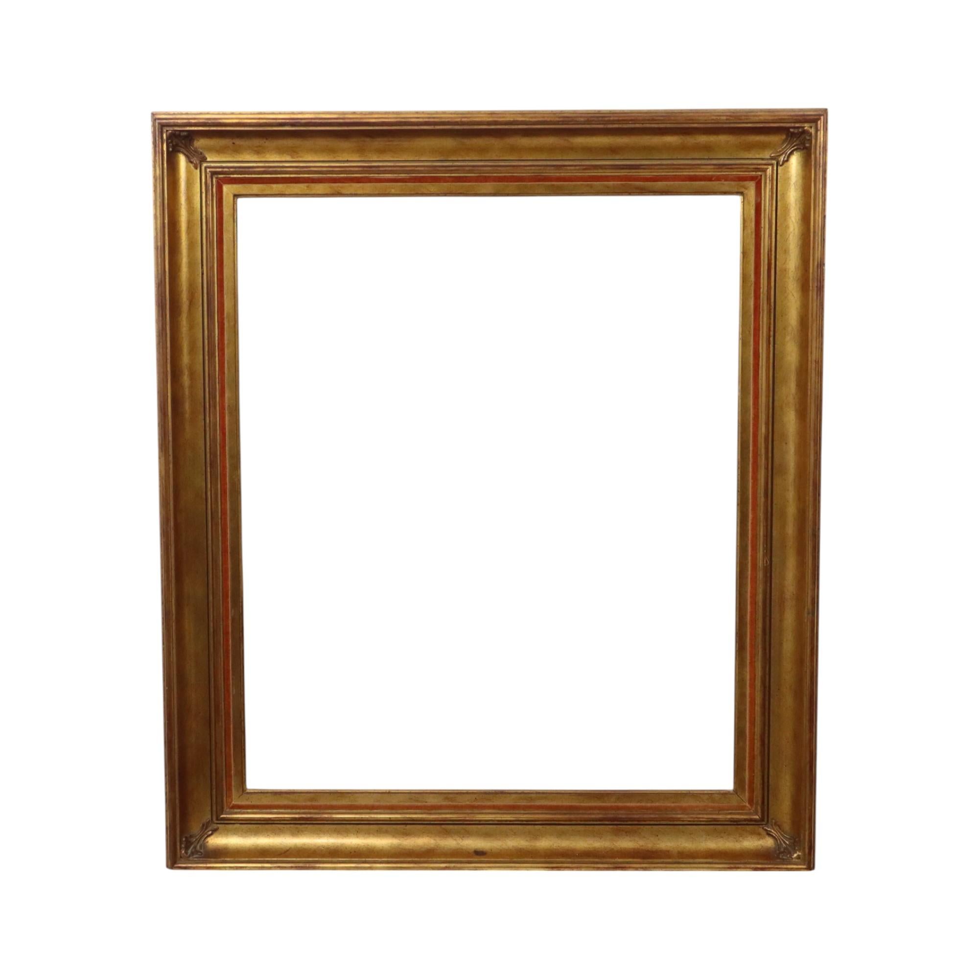 Old gold-colored wooden frame with a beautiful patina of age, entirely in classic style, decorated all around with a red velvet band and acanthus decorations in the corners, circa mid-20th century.

A nice size frame for creative use, great as a