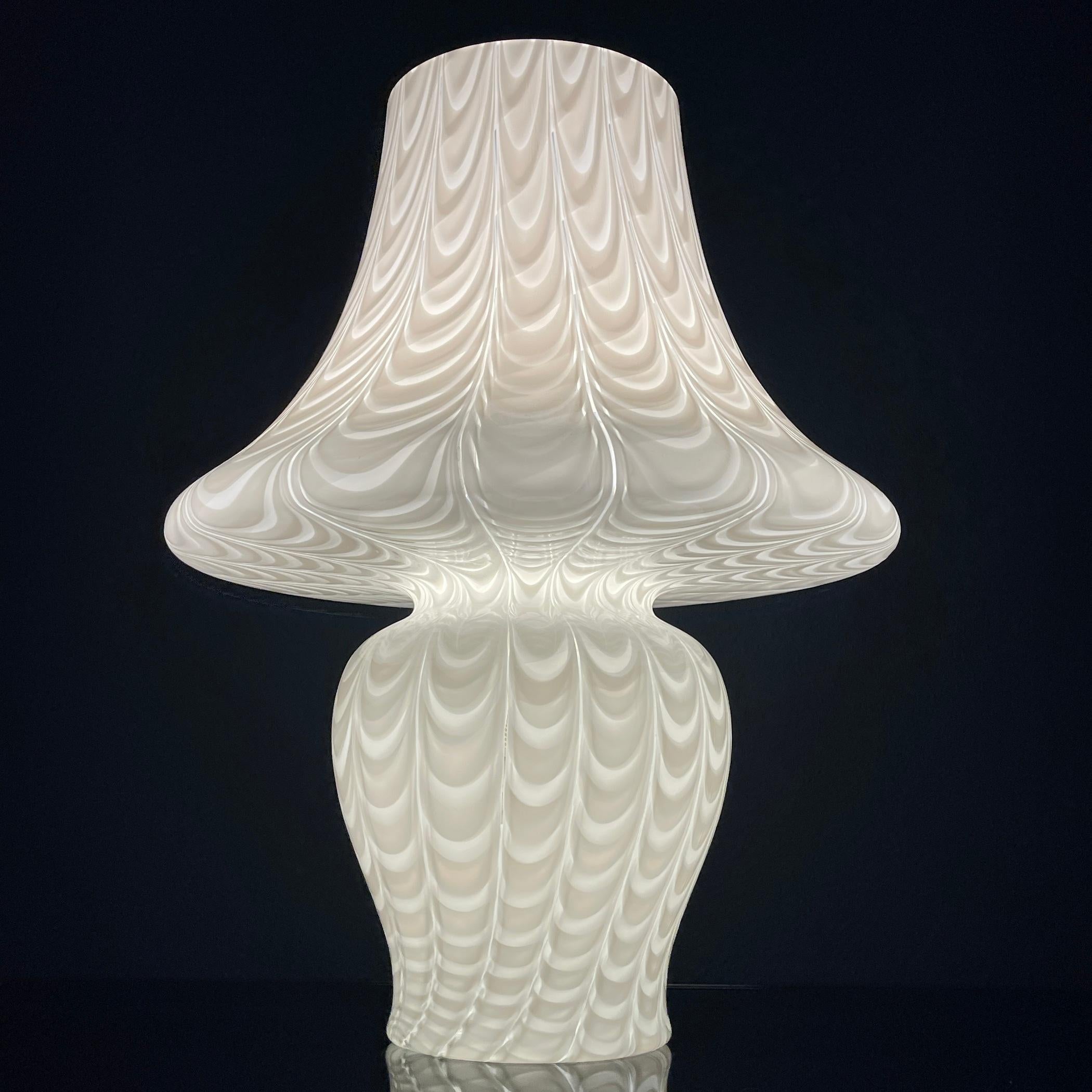 Introduce a timeless elegance to your space with the classic large white Murano mushroom lamp in stunning handblown peacock pattern, meticulously crafted in Italy during the 1970s. This exquisite piece exudes sophistication and charm, making it a