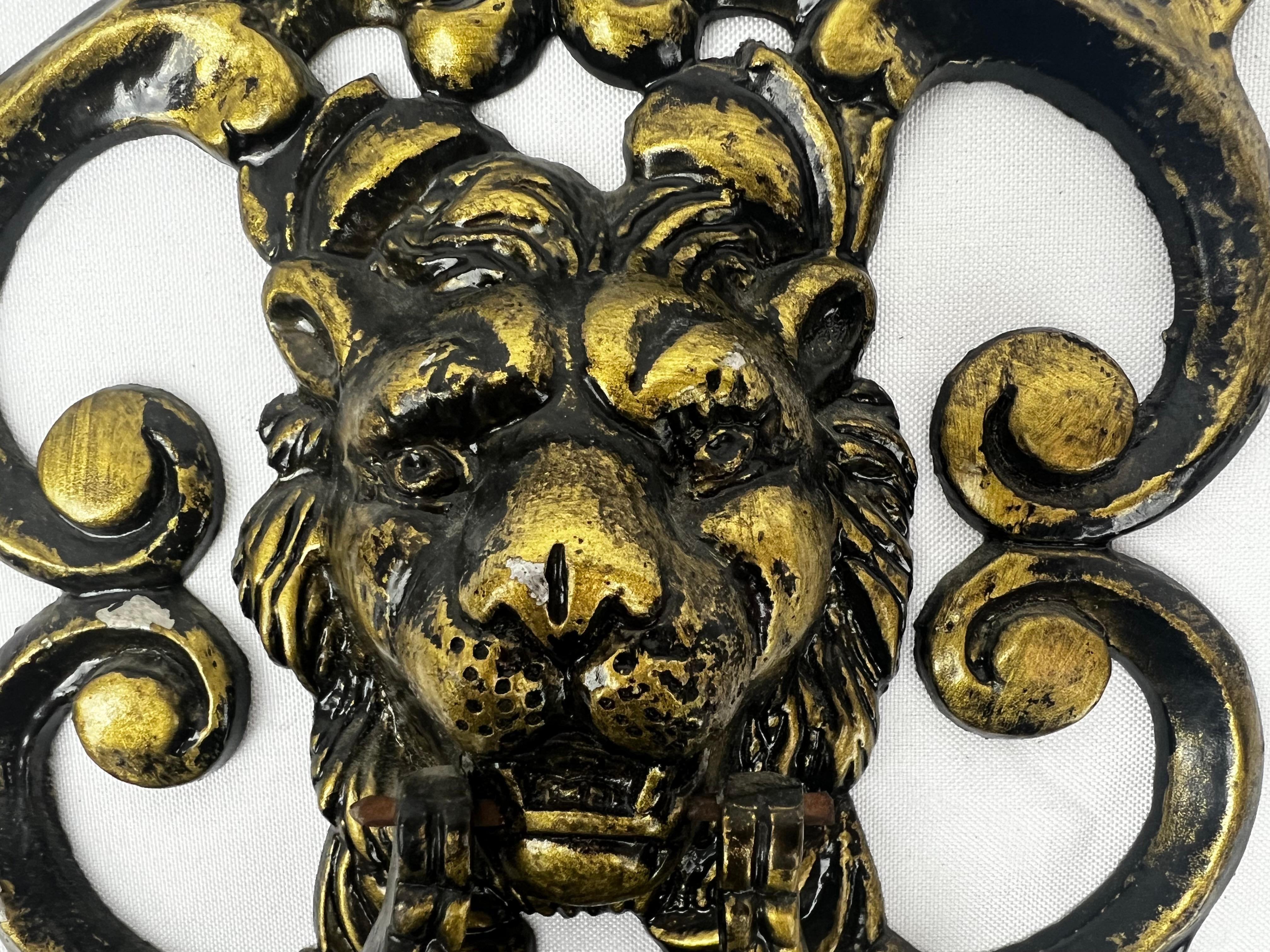 This ferocious large classical lion door knocker has been saved from a pre-eminent building in Palm Beach. The knocker is attached at either side of the mouth and is operational. There are foliate scrolls surrounding the lion's face. It has been