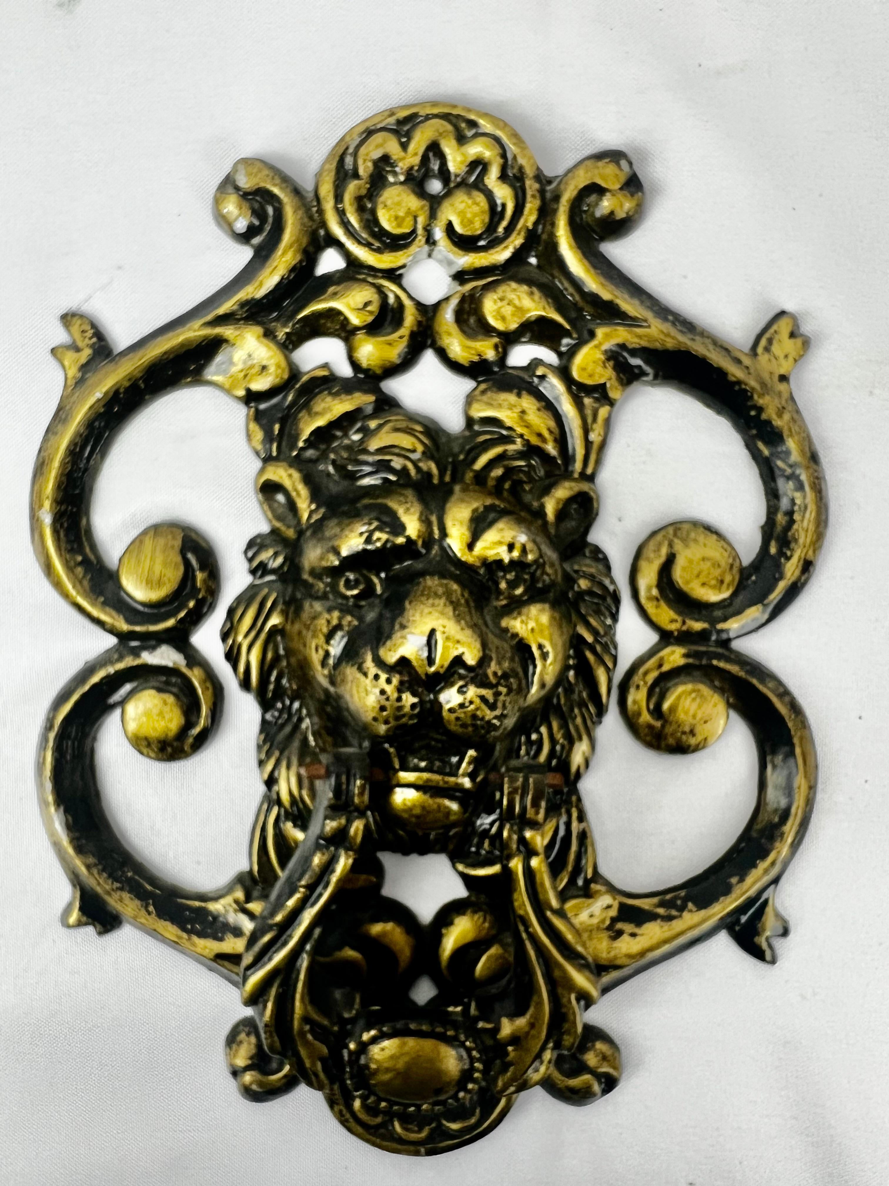 This ferocious large classical lion door knocker has been saved from a pre-eminent building in Palm Beach. The knocker is attached at either side of the mouth and is operational. There are foliate scrolls surrounding the lion's face. It has been