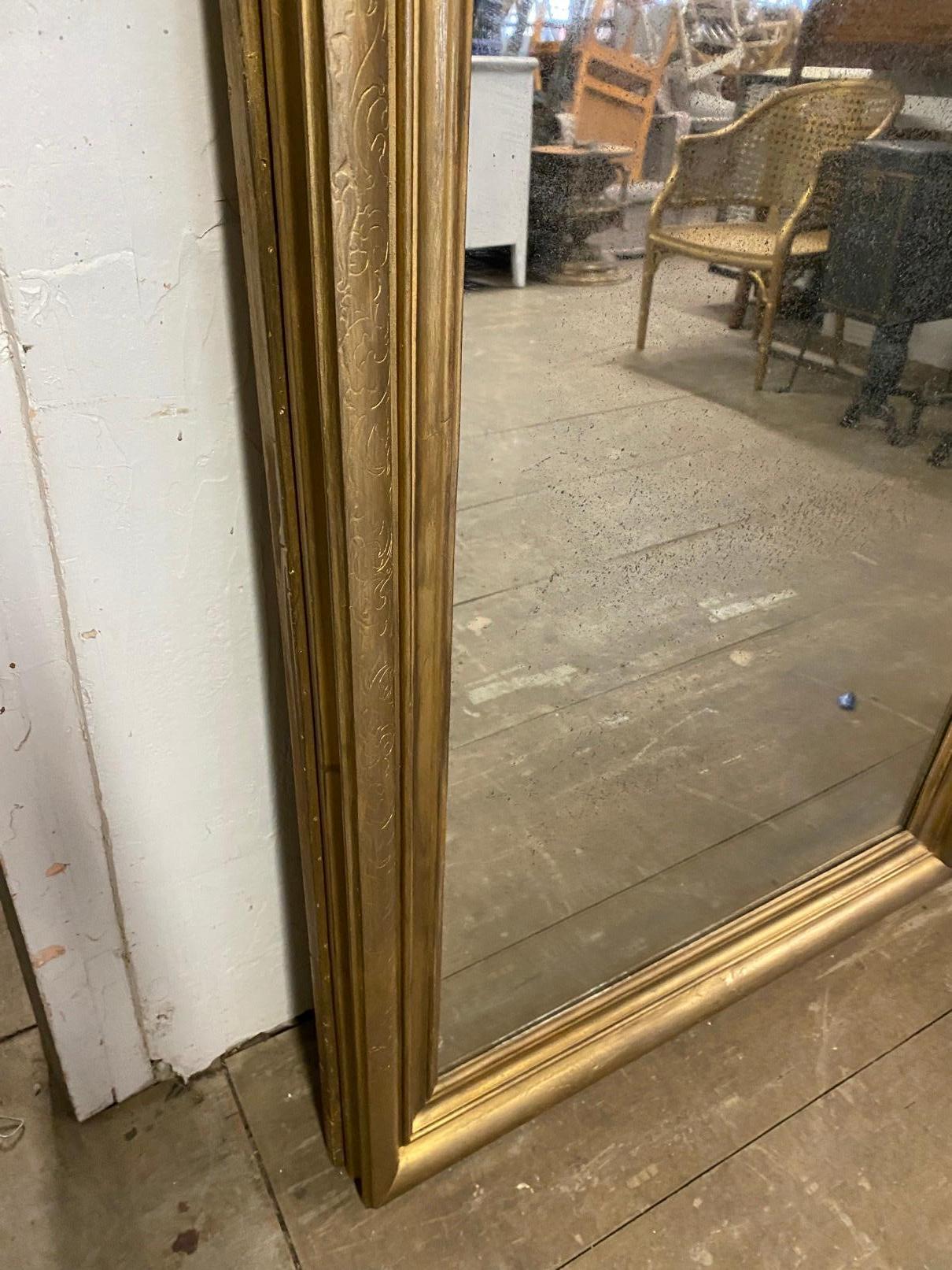Large gold gilt classical mirror can be hung in either direction. Mirror is suited for pier, console, mantle or fireplace. The simple elegant style lends itself to fit into most decor.
The mirror has been refinished and some of the original detail