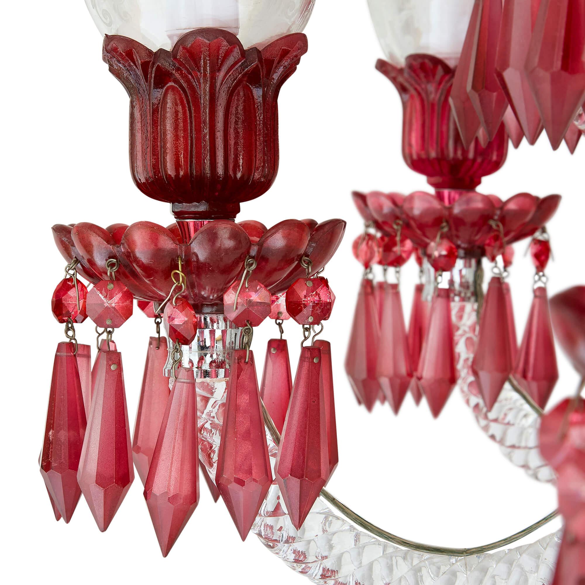 Large clear and red cut glass chandelier 
Continental, 20th Century
Height 108cm, diameter 108cm

With its sensational design, this chandelier effectively conjures up the opulence of the Belle Époque period. The red glass central stem of the