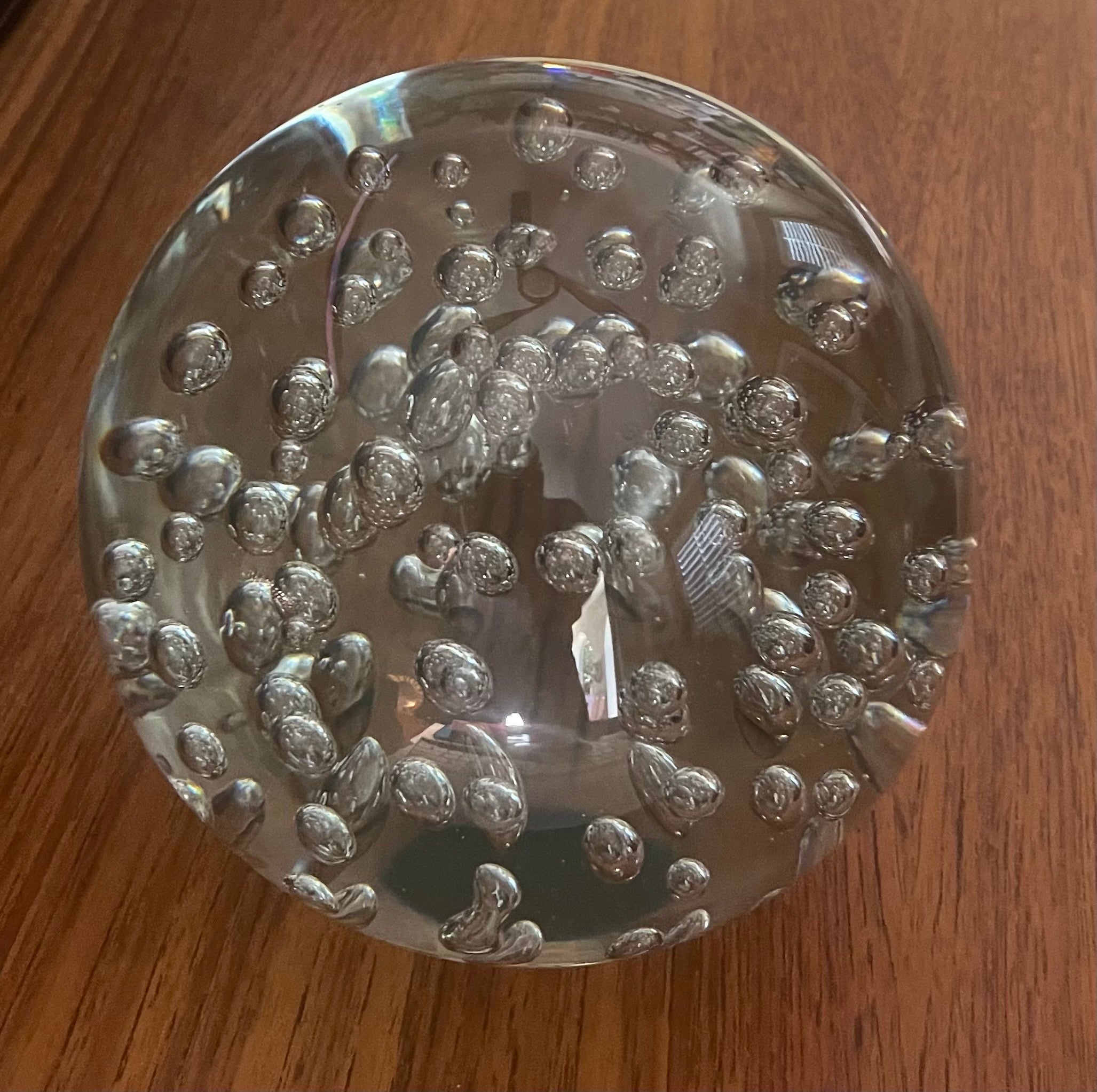 A large clear art glass orb sculpture or paperweight with bubbles, circa 1990. The orb is layered with internal air bubbles and measures 6.6