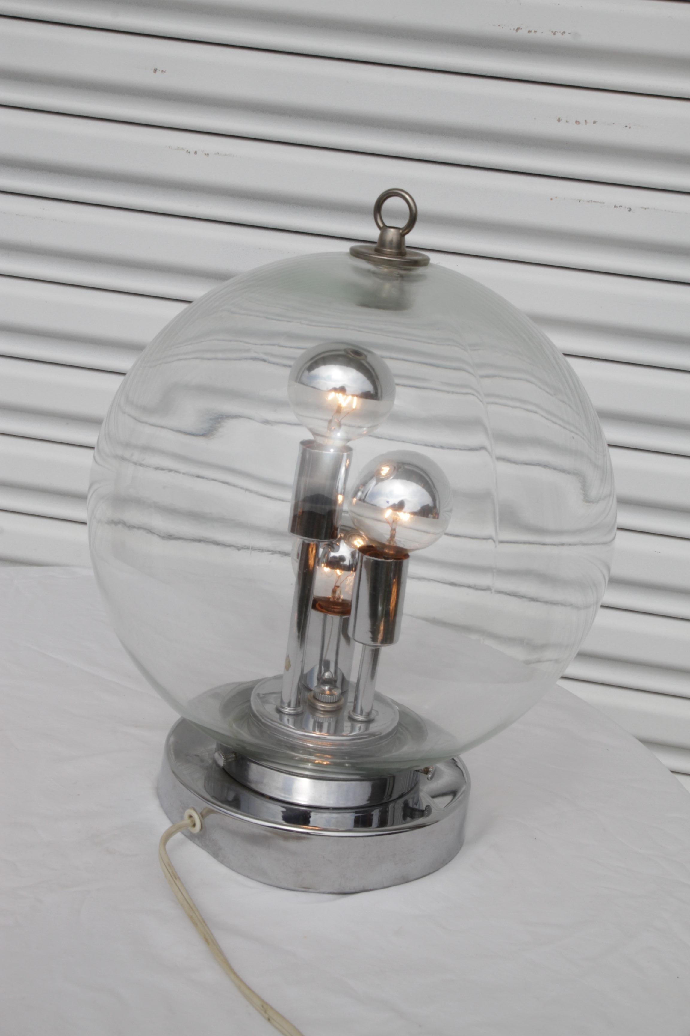 Looks very sculptural with the sphere, the pockets of air trapped inside and the mirrored bulbs. Inside is three chrome pillars each with light sources. All original and absolutely mint condition.

Dimensions:

Height: 15