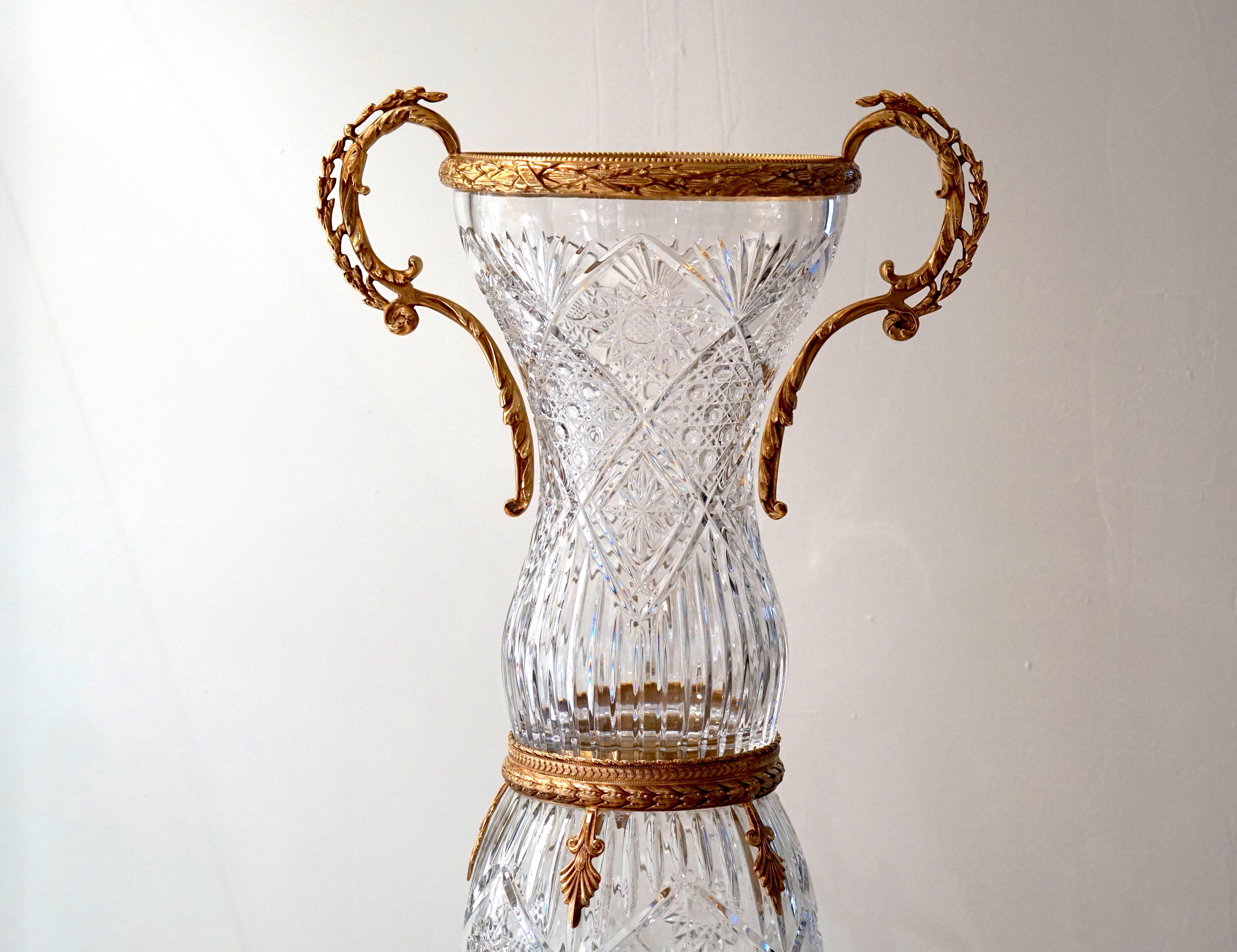 Majestuous clear crystal vase with a palmier design, embellished with gold covered bronze.

Impressive work on the 22-carat gold covered bronze. 

High quality crystal handcrafted. 

The crystal is embellished with 22-carat gold, which makes