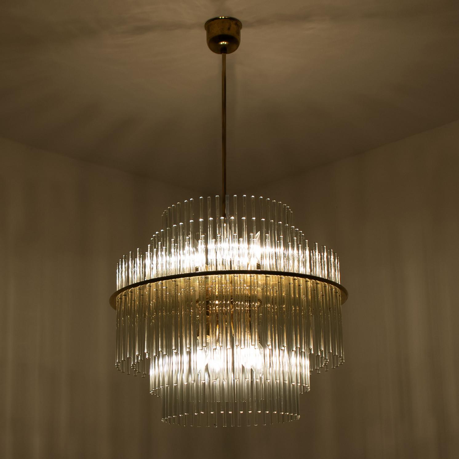 Clean lines to complement all decors. Wonderful high-end light fixture by Sciolari. With brass detail hanging glass giving the piece an elegant appearance which refracts the light, filling a room with a soft, warm glow.

The chandelier has brass