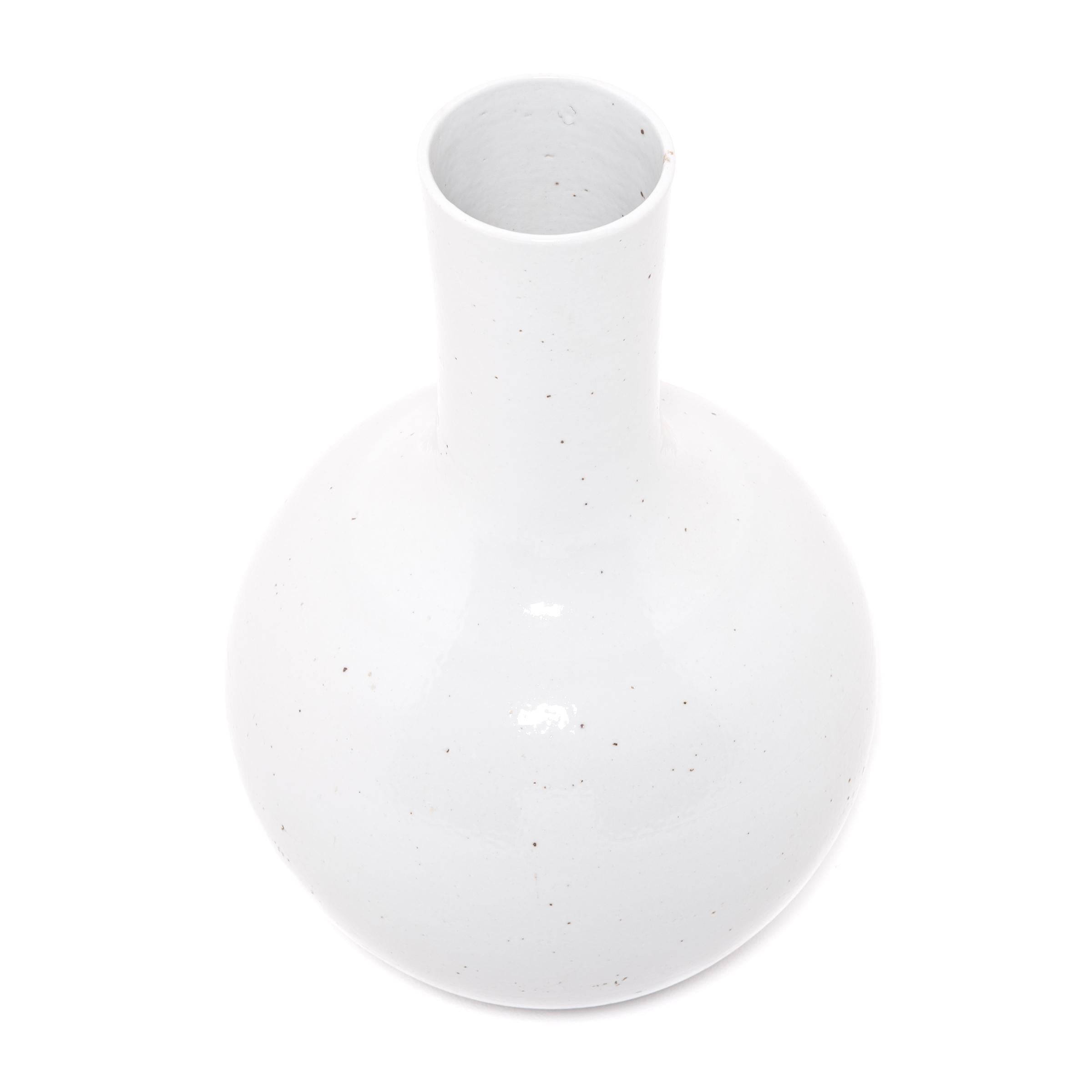 S'inspirant d'une longue tradition chinoise de céramiques monochromes, ce vase austère à long col est émaillé d'un blanc serein, inspiré des nuages. Fabriqués dans la province du Zhejiang, les céramistes locaux ont réinterprété cette forme très