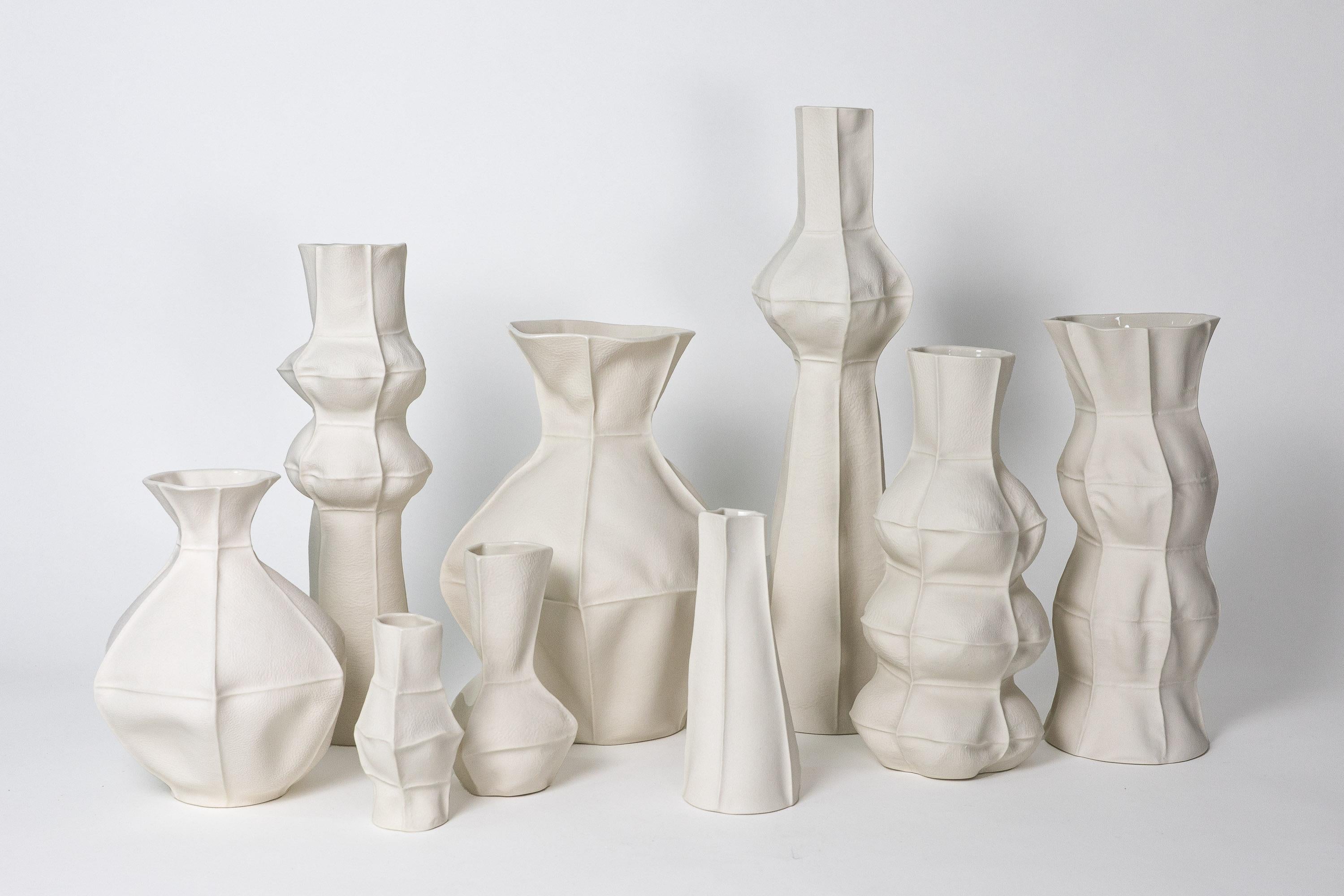 Un grande gruppo di 9 vasi in porcellana unici, tattili e organici, con superficie esterna testurizzata in pelle e interno smaltato trasparente. Grazie al processo di produzione, ogni articolo è unico nel suo genere. Il set comprende 9 vasi come