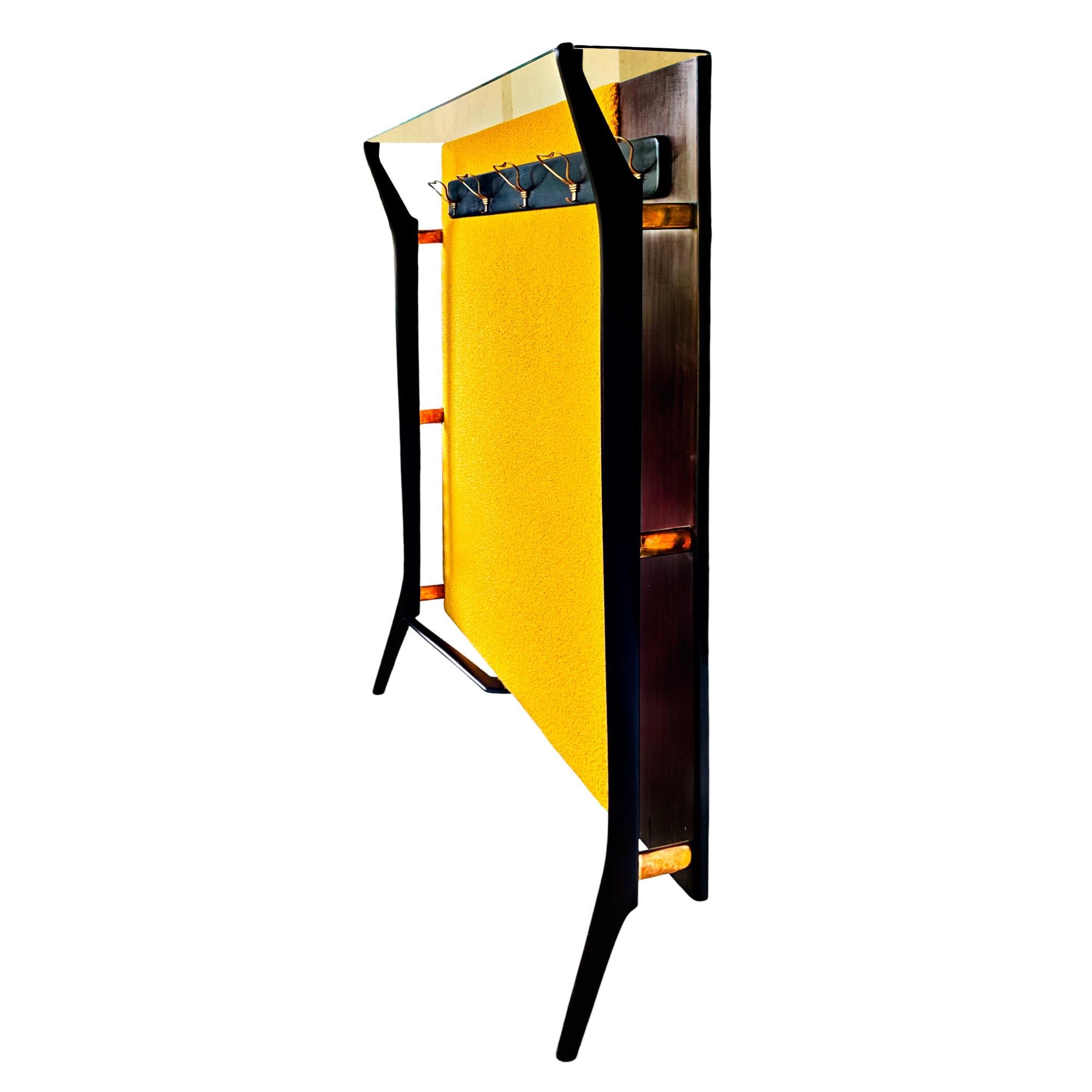 Large coat rack in stained and waxed mahogany, brass hooks and details, new fillings and upholstery in golden yellow bouclé fabric. Glass shelf on top.

Italy, circa 1950