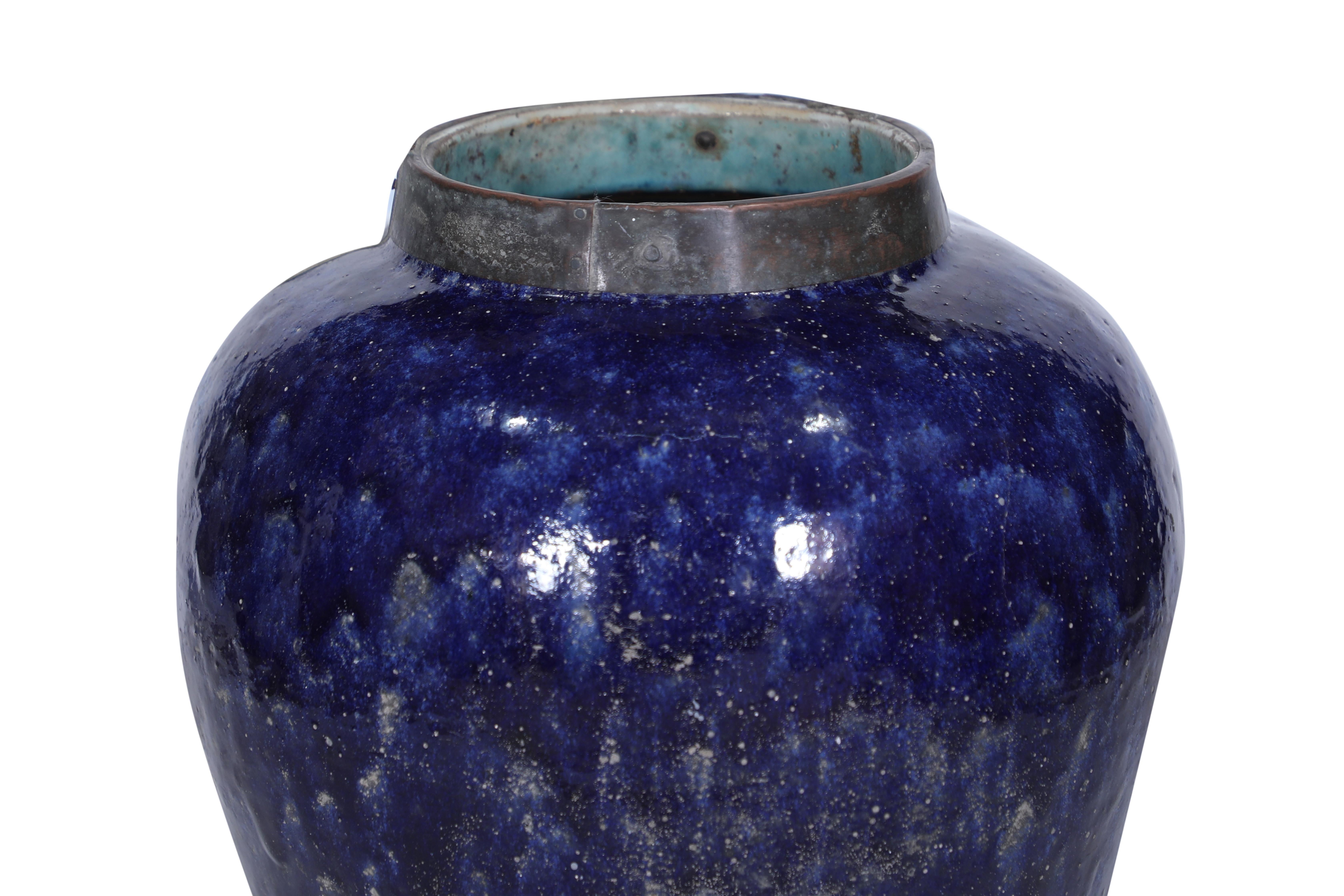 An Asian ceramic large tea container with an amazing cobalt blue glaze.  Brass collar.  Beautiful shape and in good condition.  Could also be used as a planter.  Opening of the mouth of the urn is 9