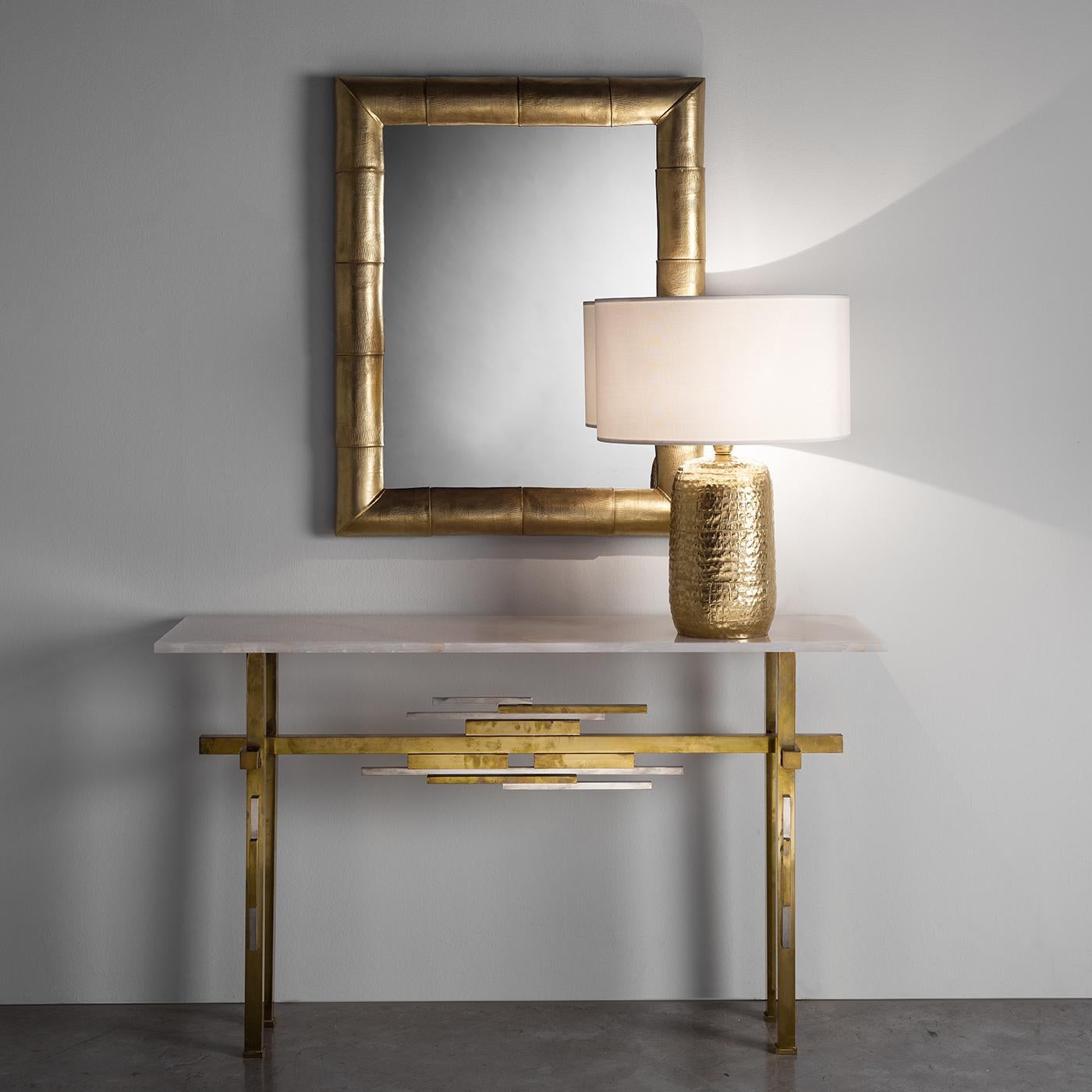 An exercise in contrasts, this stunning table lamp is a work of art to display in both a Classic and contemporary interior to add a dynamic and sophisticated accent. The linear fabric shade in traditional drum shape tops a magnificent base in metal