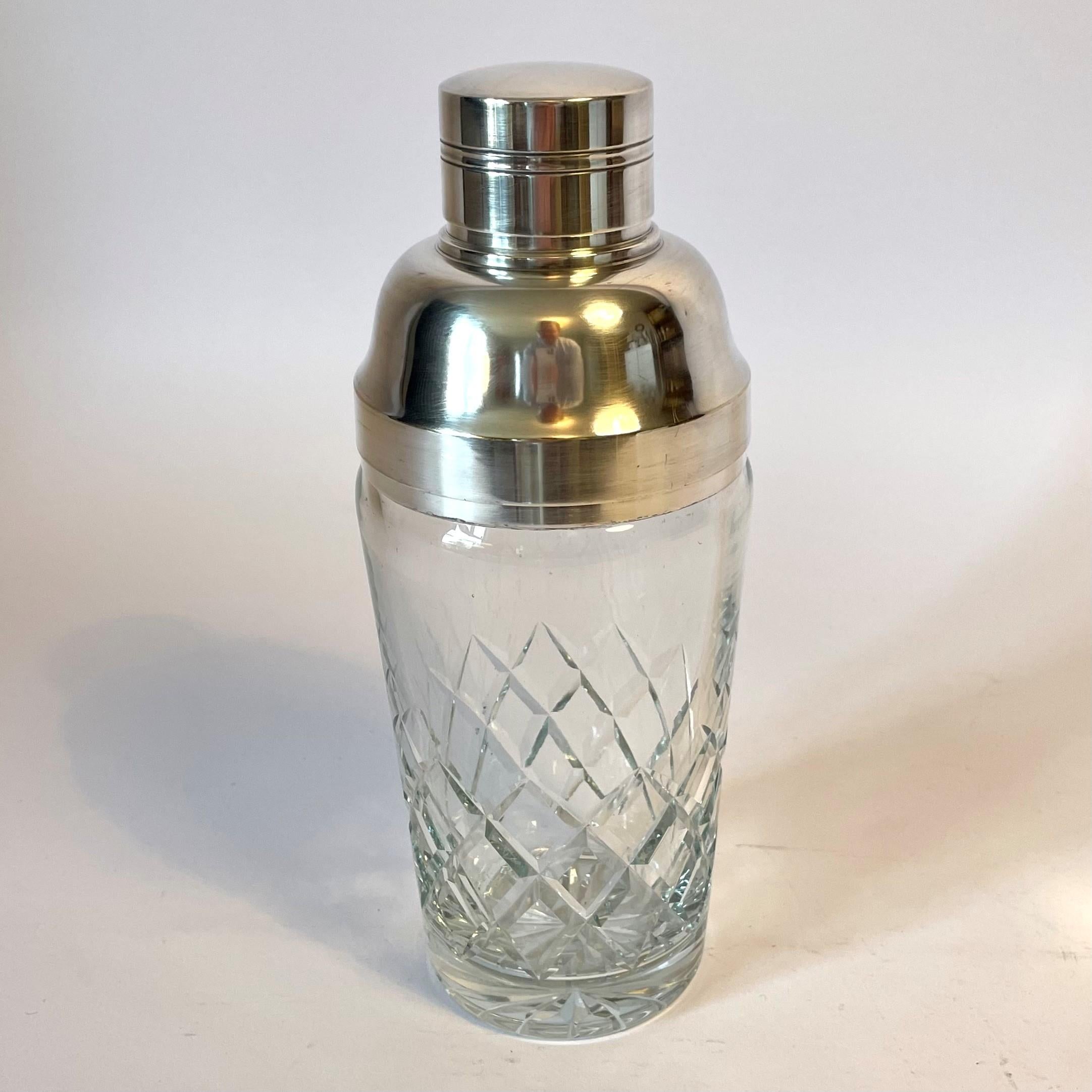 Large cocktail shaker in Chrystal with silver plated top. Elegant in its design and is of high quality. Probably manufactured in the 1940s -1950s.

Wear consistent with age and use.