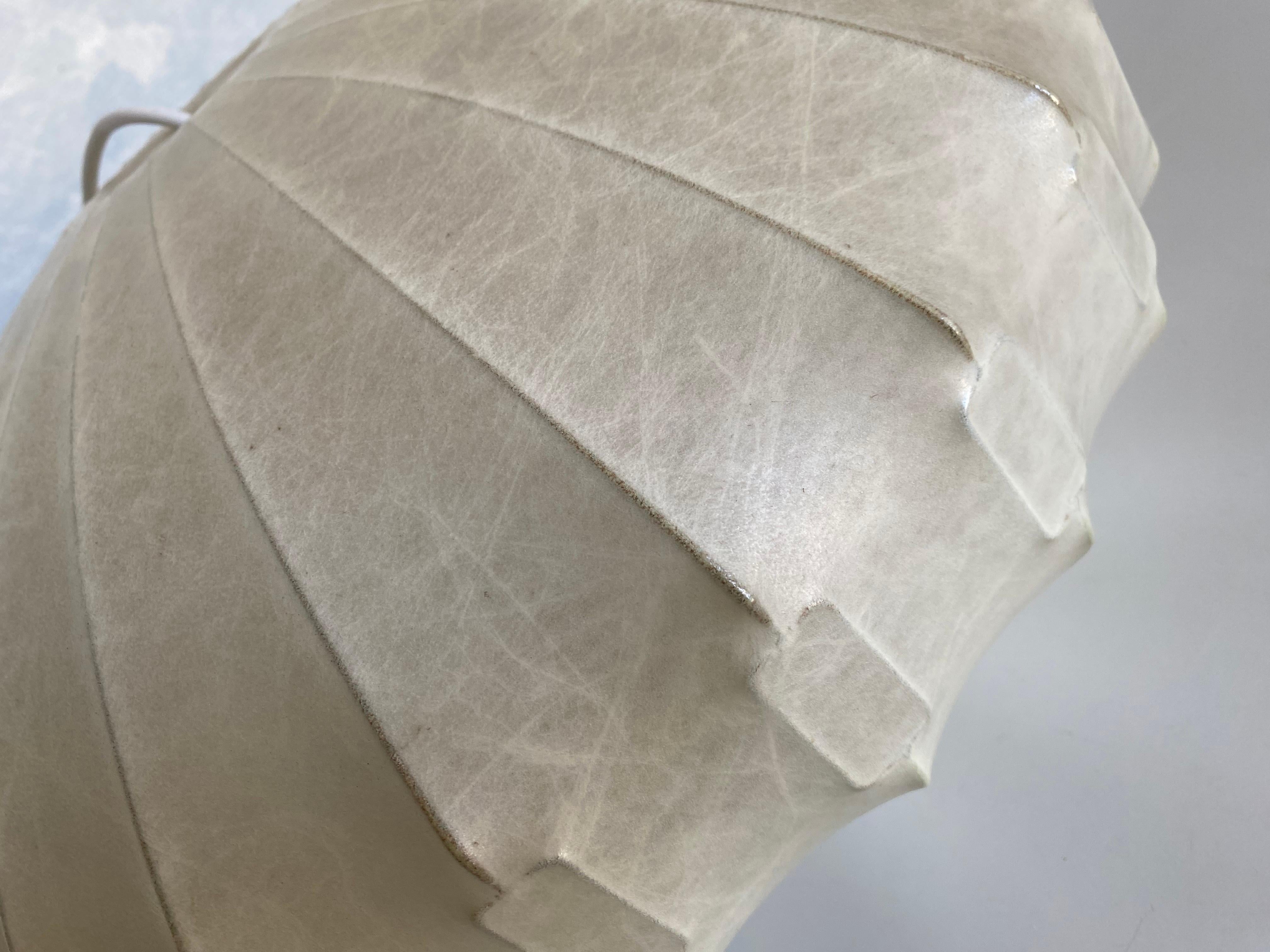 Questa lampada a sospensione a forma di bozzolo di grandi dimensioni, rara e insolita, risalente agli anni '60, è in ottime condizioni e, data la sua età, mostra solo pochi segni di utilizzo.

Il bozzolo ha un diametro del corpo di circa 47 cm e