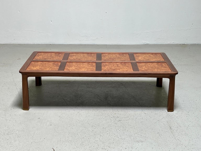 A large walnut and burled elm coffee table with brass feet. Designed by Edward Wormley for Dunbar.