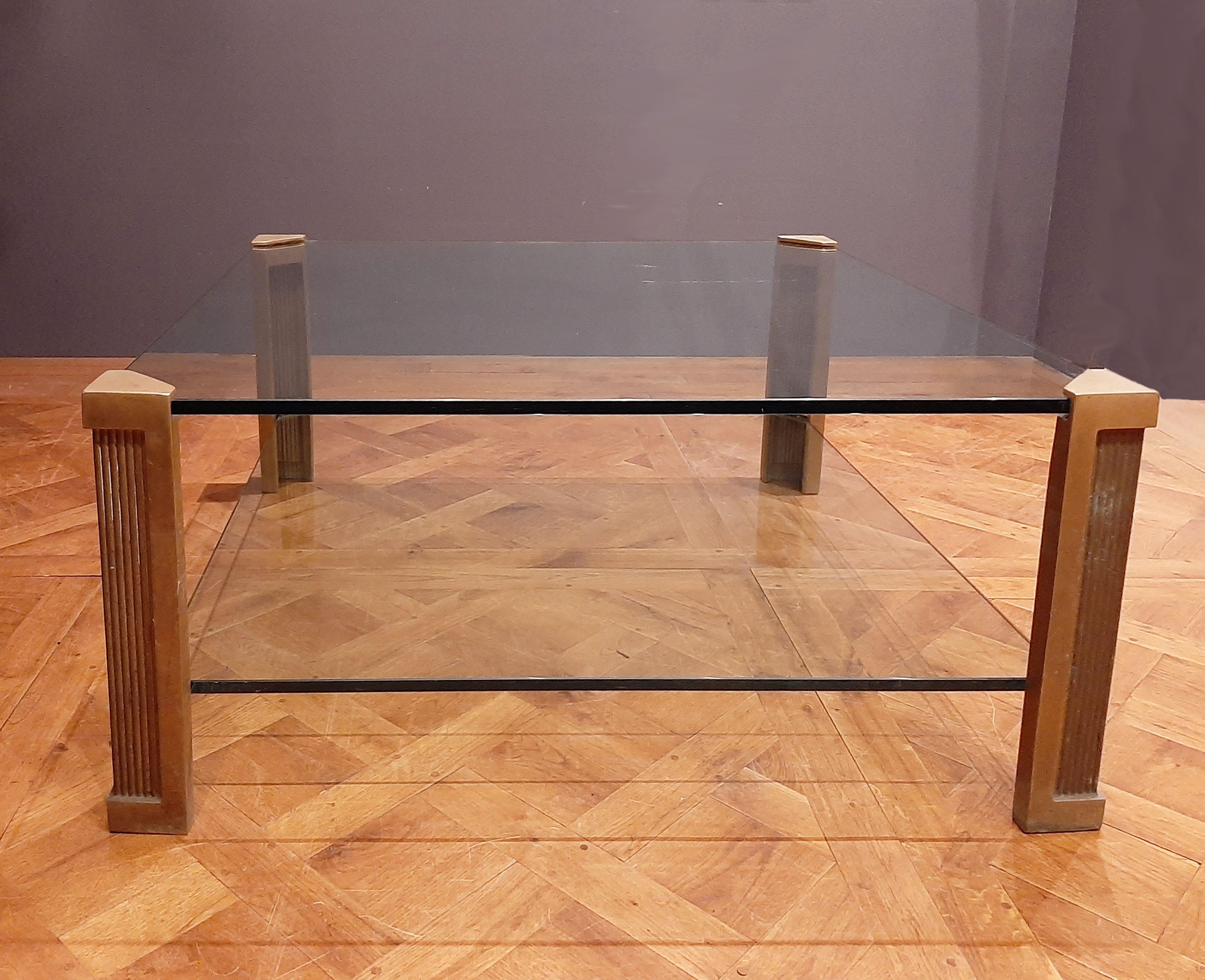 Large coffee table model T14 by Peter Ghyczy (budapest 1940) for studio Ghyczy in the 1970s. Two thick clear glass shelves with vertically ribbed brass legs. The glass top and shelf are attached to the table using the clamping technique developed by