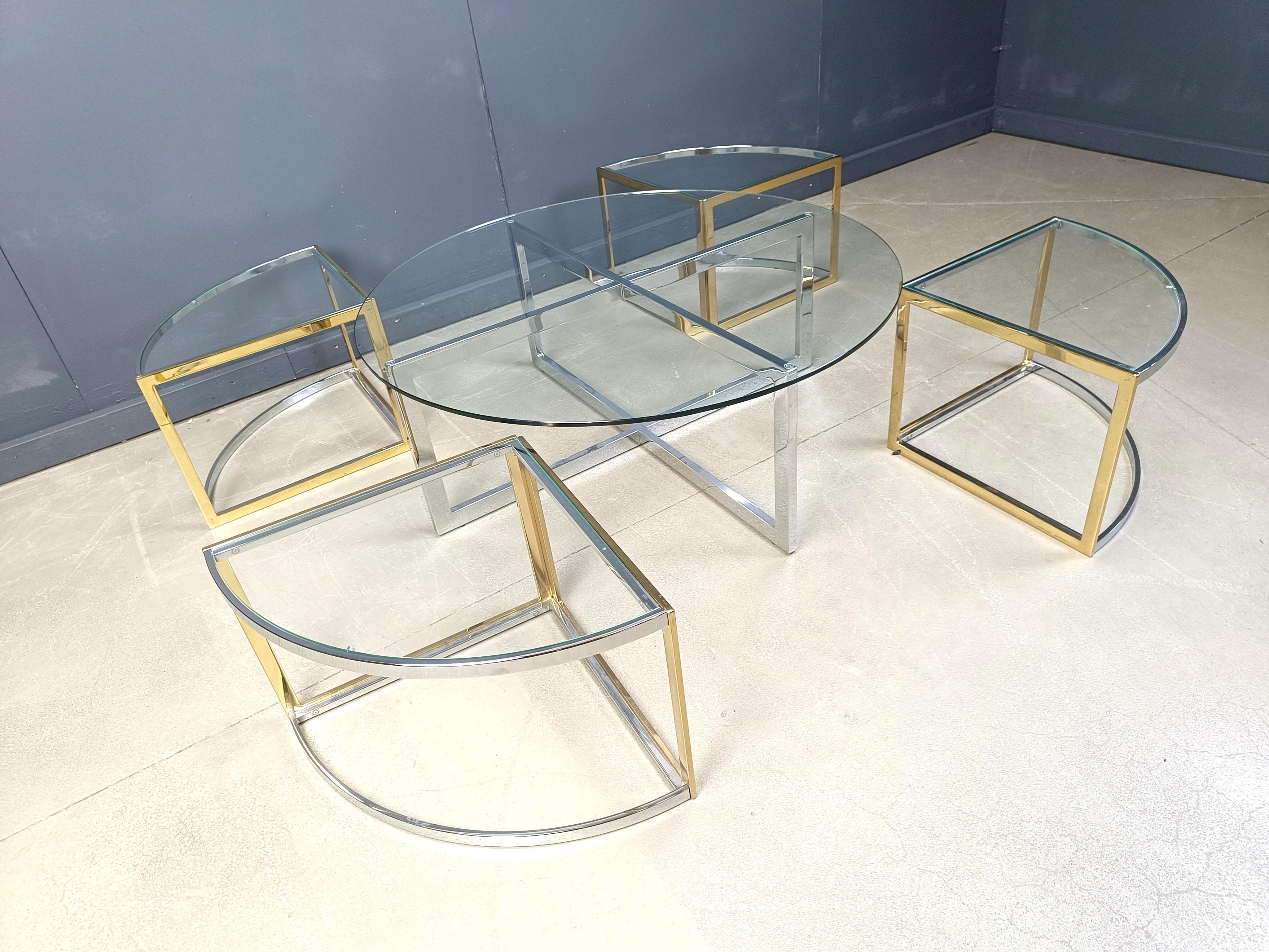 Large coffee table set by Maison Charles consisting of 4 nesting tables in brass and chrome with clear glass tops and a large chrome coffee table.

This coffee table set can be used in multiple ways, Ideal for when you have guest come over, think of