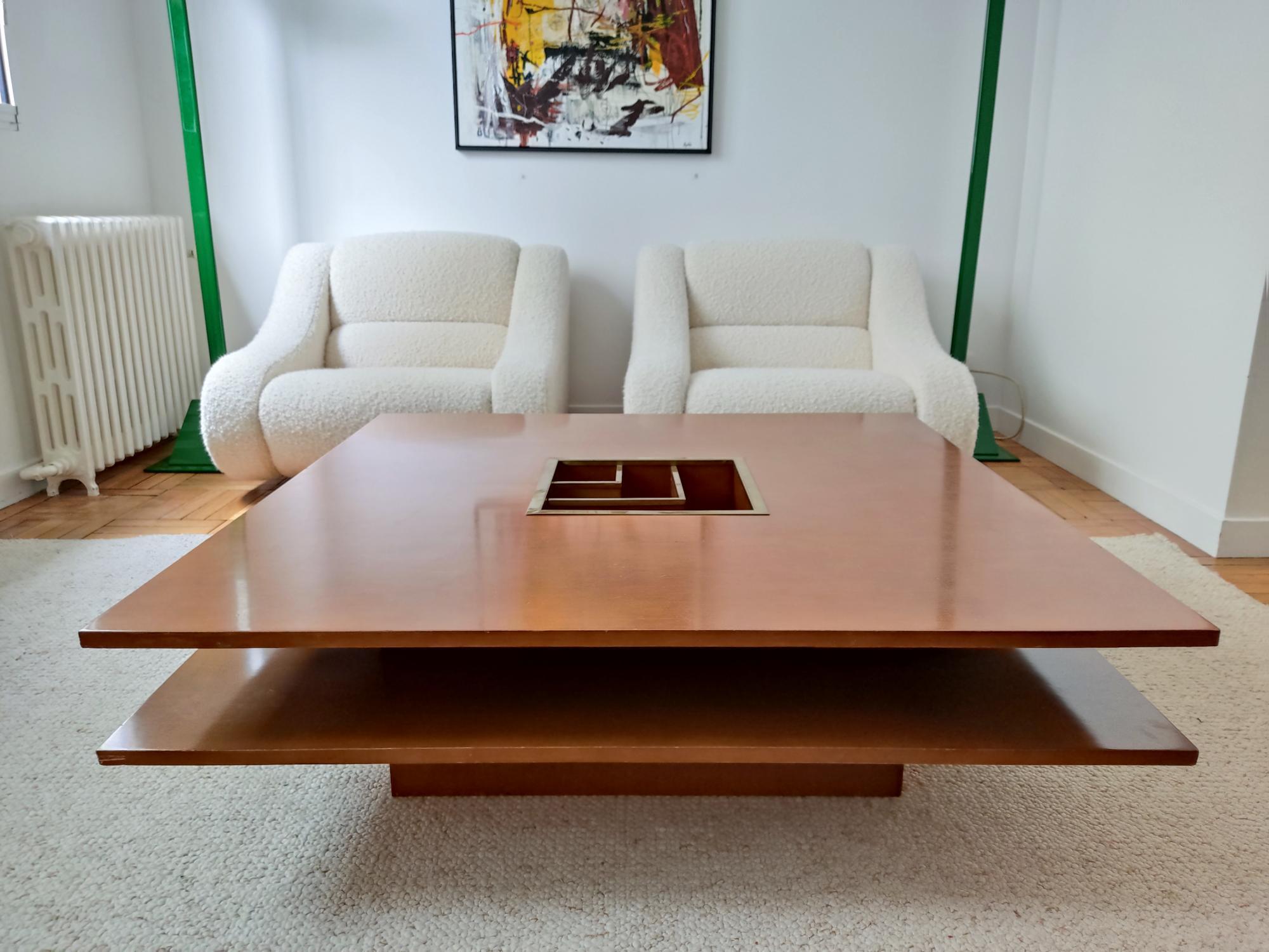 Large Italian coffee table from the 1970s. The double square wooden top gives it an airy side. The integration of a graphic brass tray in the middle gives a lot of chic and elegance to this table.
slight missing wood on the edges which can be