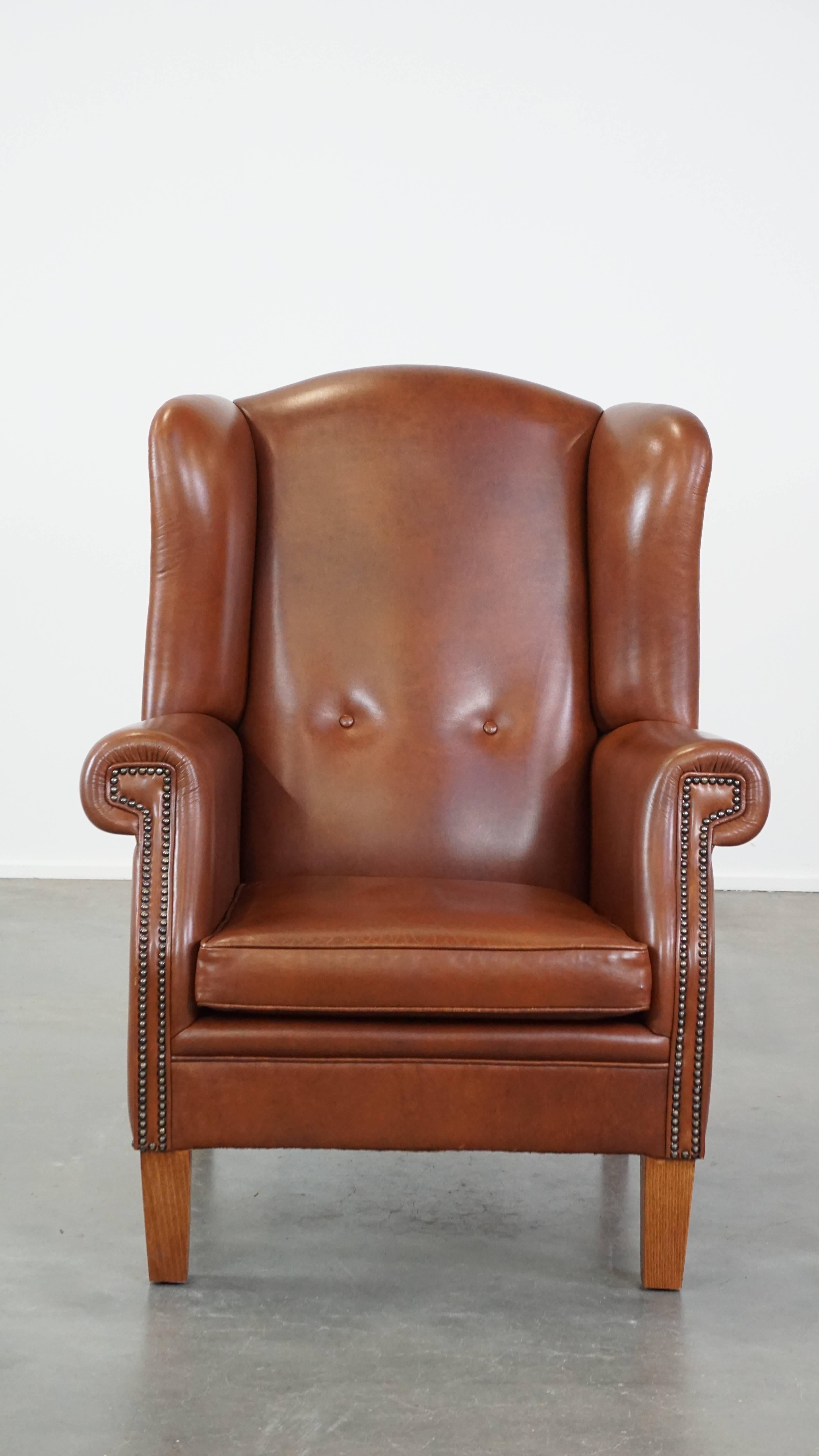 Este increíble sillón orejero de cuero color coñac encaja fácilmente en casi cualquier interior. Este gran sillón orejero es un ejemplo perfecto de la mezcla inglesa de elegancia, calidez, lujo y comodidad. Tiene un cojín de asiento suelto y ofrece