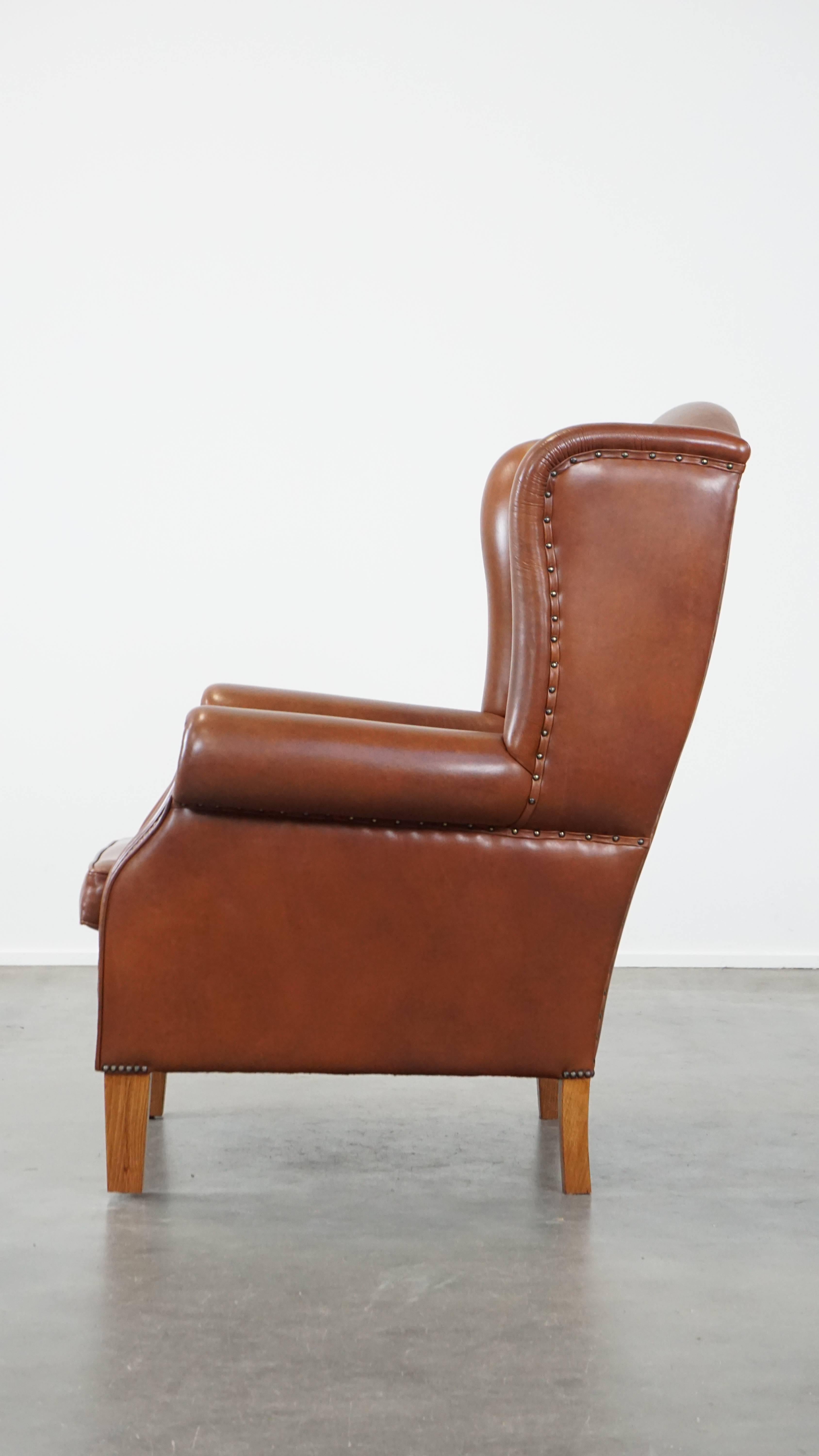 Gran sillón orejero de cuero color coñac en buen estado de estilo inglés siglo XX en venta