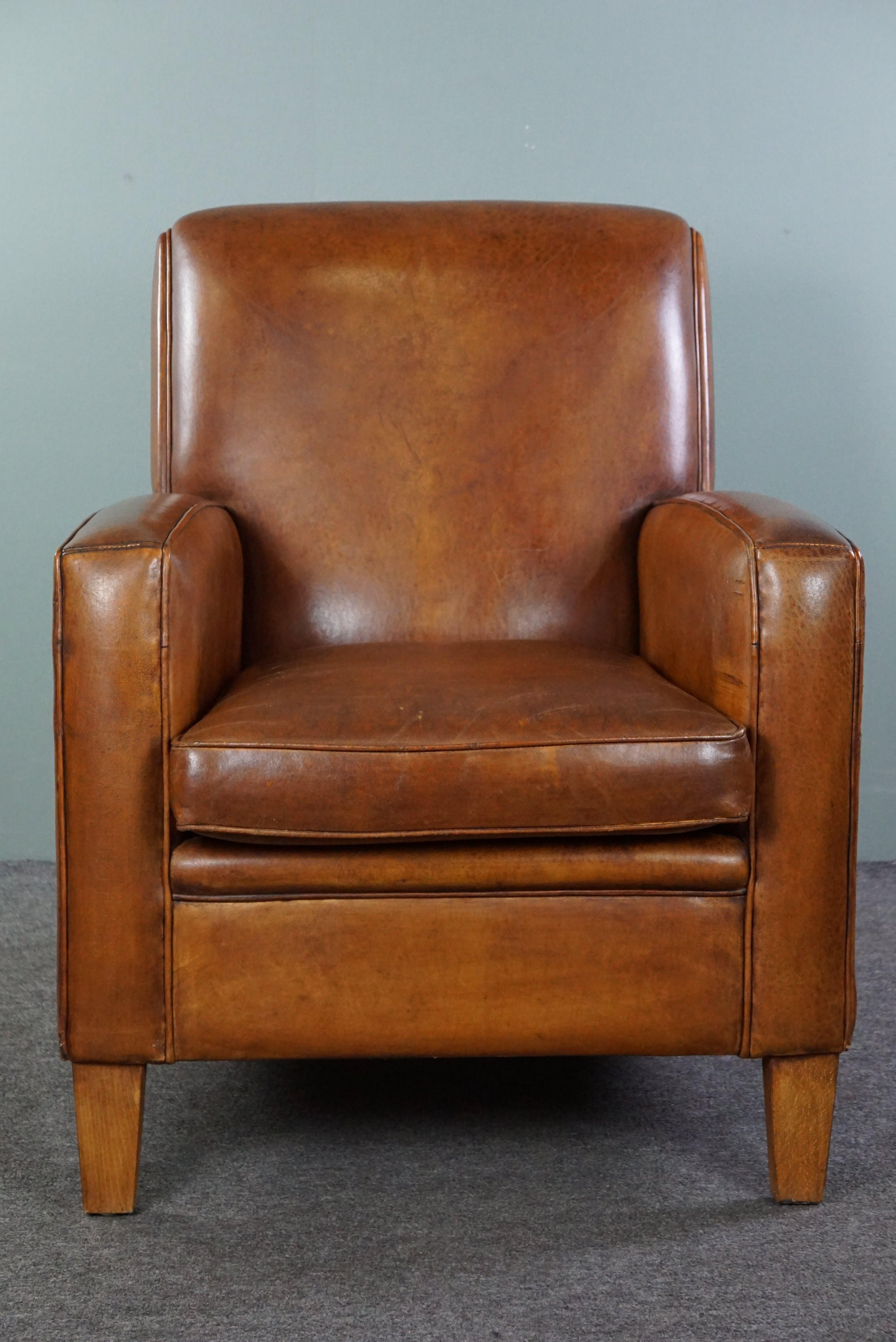 Offered is this well-maintained sheep leather design armchair. Enrich your interior with this beautiful cognac-colored armchair made of sheep leather. The armchair is in good condition and not only offers comfort but also adds stylish elegance to