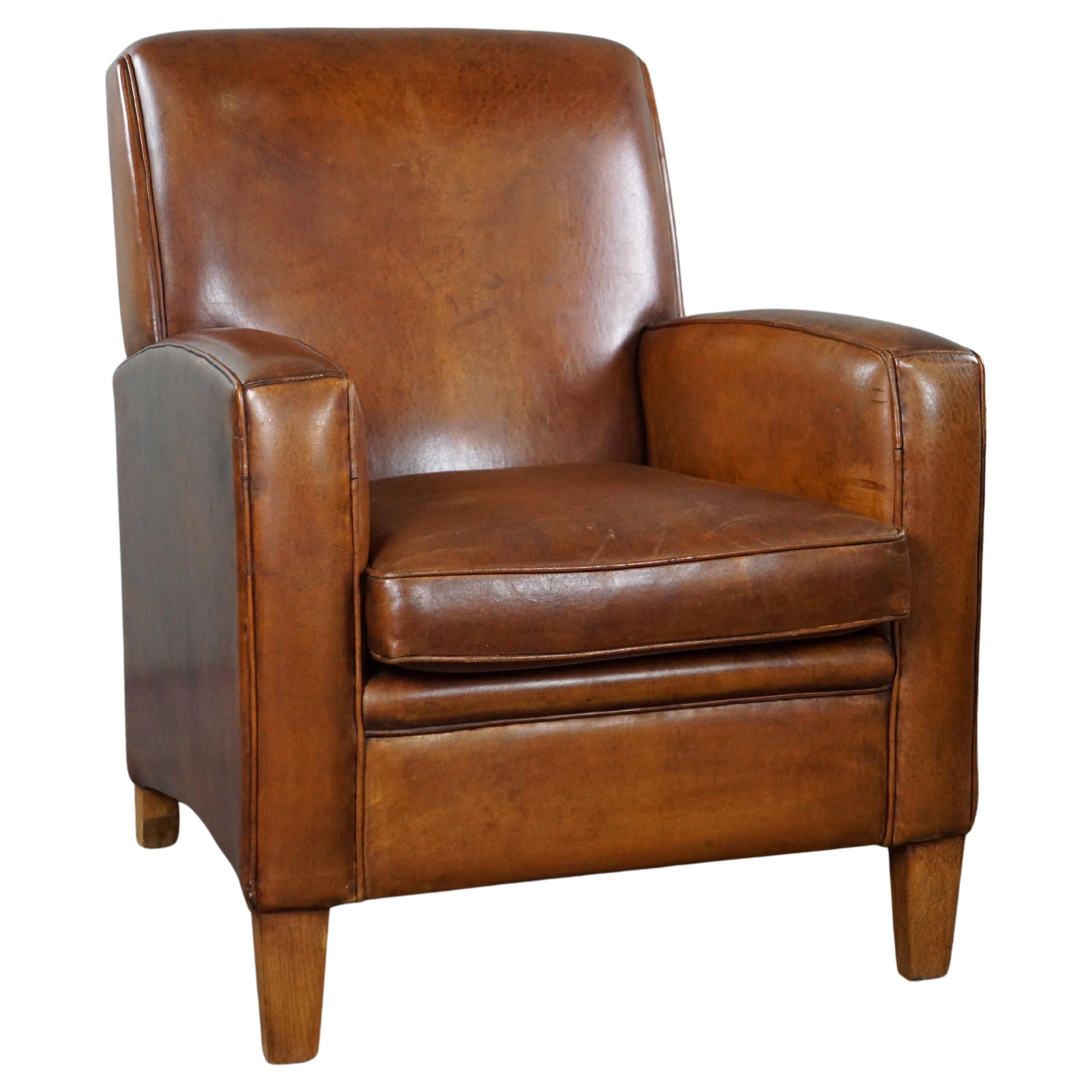 Large cognac-colored sheep leather armchair in good condition with a sleek desig For Sale