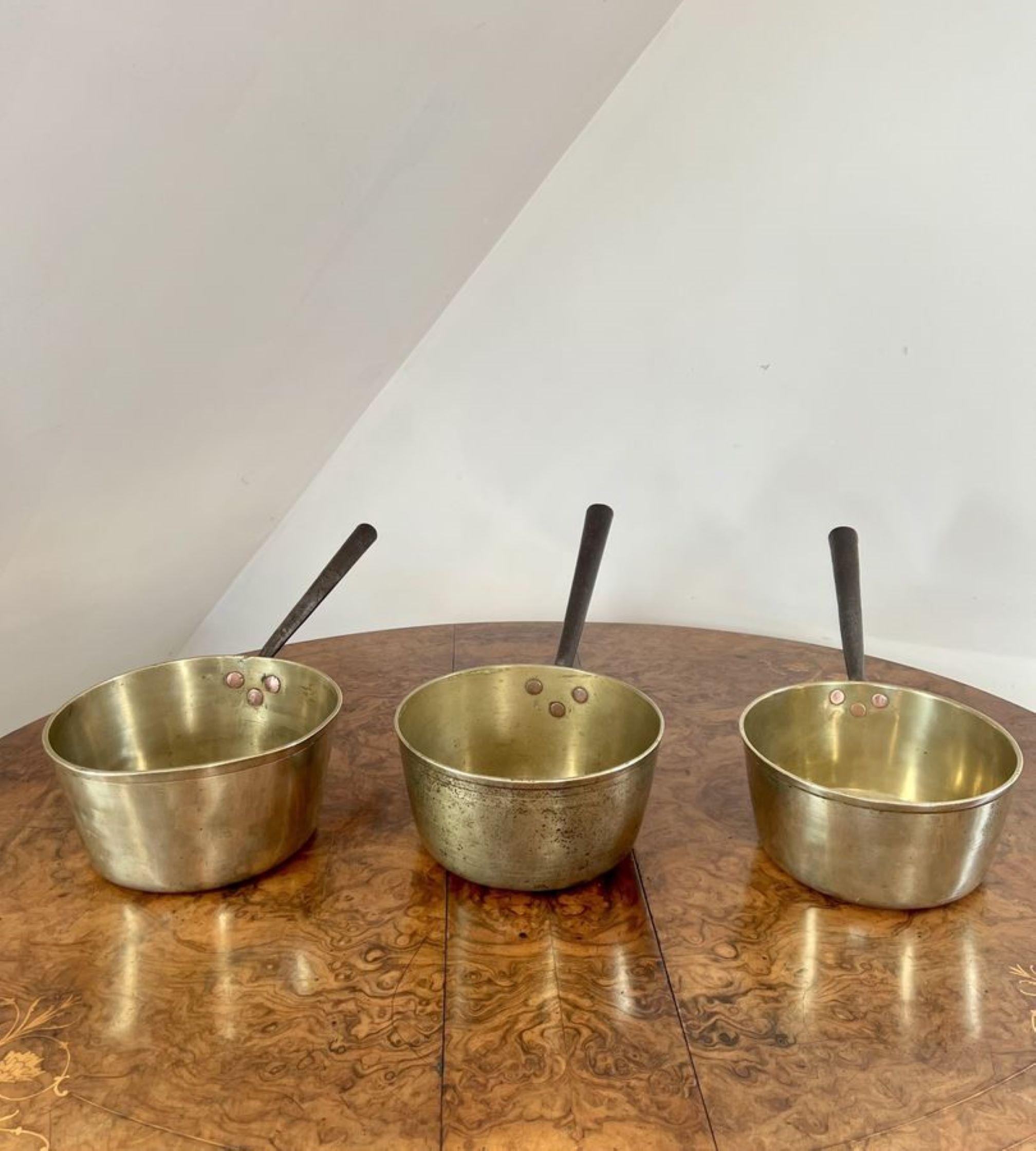 Large collection of antique Victorian heavy brass saucepans having a large collection of eight heavy brass sauce pans consisting of various sizes with long iron handles. 

D. 1860
