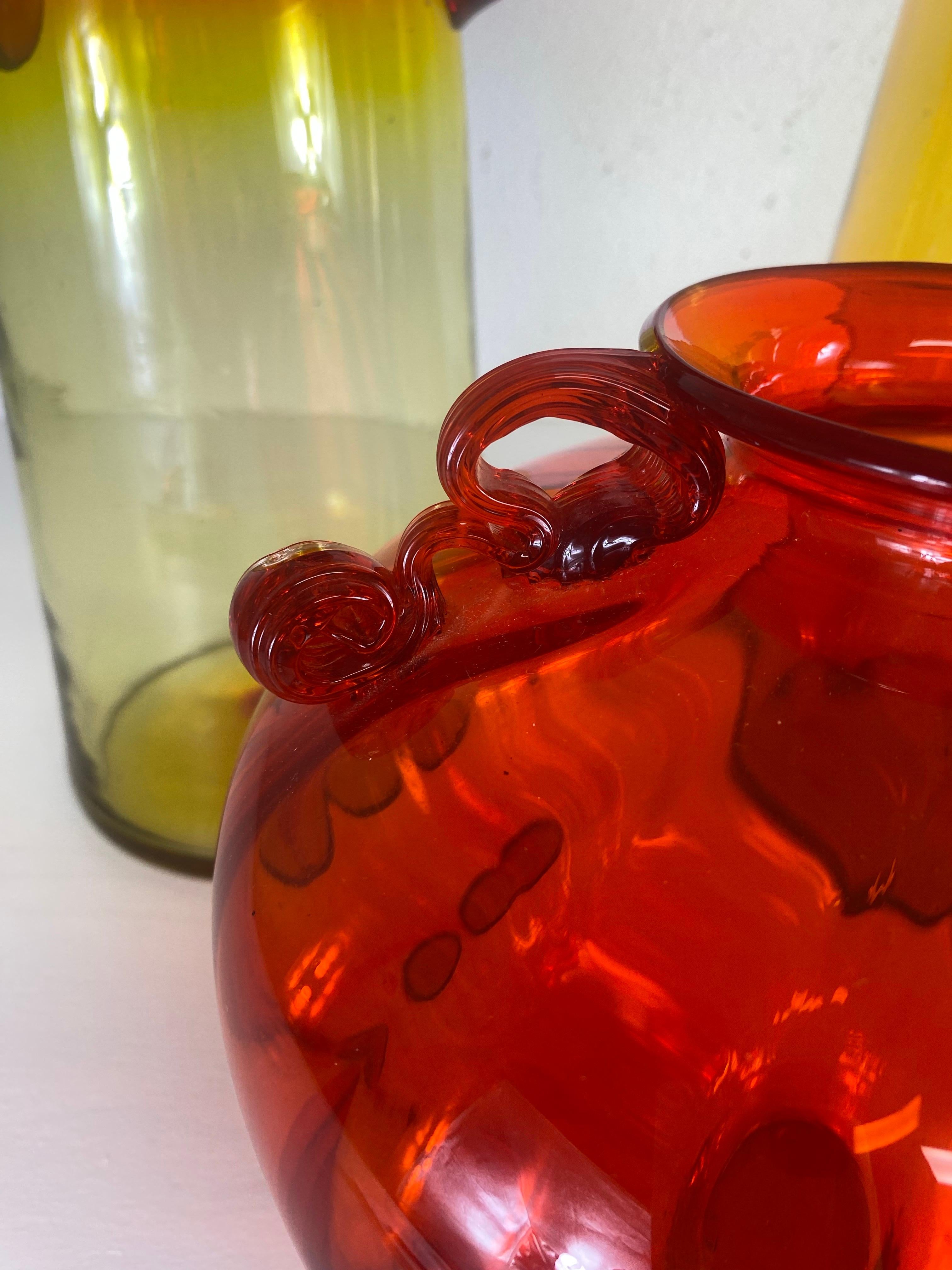 This is a large collection of mid-century vintage handblown Blenko and Impoli Rossi jars. This collection of jars are in tones of amber and red. The largest amber jar is 8“ x 8“ x 34“ tall. The large red vase is 8“ x 8“ x 20“ tall. The amber picture
