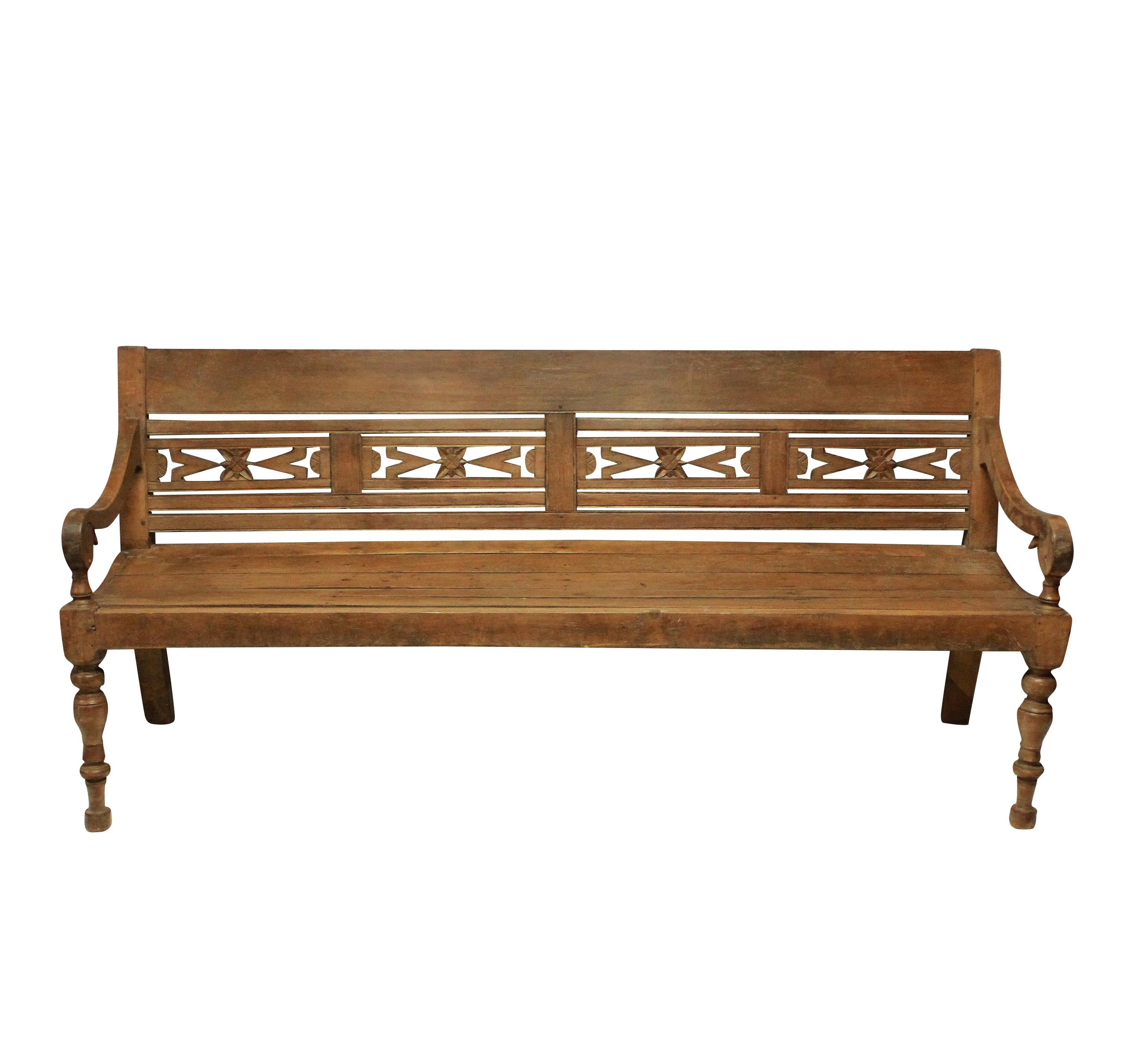 A large Anglo-Indian hall bench in carved teak.