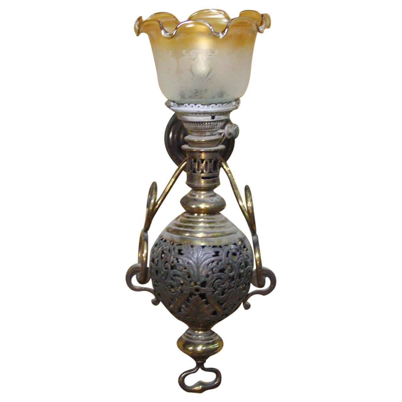 Pair of large Colonial style Hurricane lamps with gold tipped scalloped glass. The iron body of the lamp features floral scrolls and an iron key to adjust the gas. This sconce has been recently wired electrically.

 