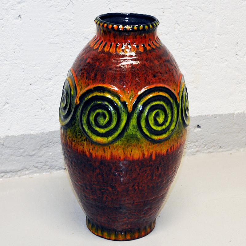 Lovely large and colorful vintage ceramic vase from West Germany 1970s. Oval rustic vase of clay colored in a beautiful mix of earth colors, mustard yellow and green glaze blended with brown. Relieffs of green circle patterns on the surface.