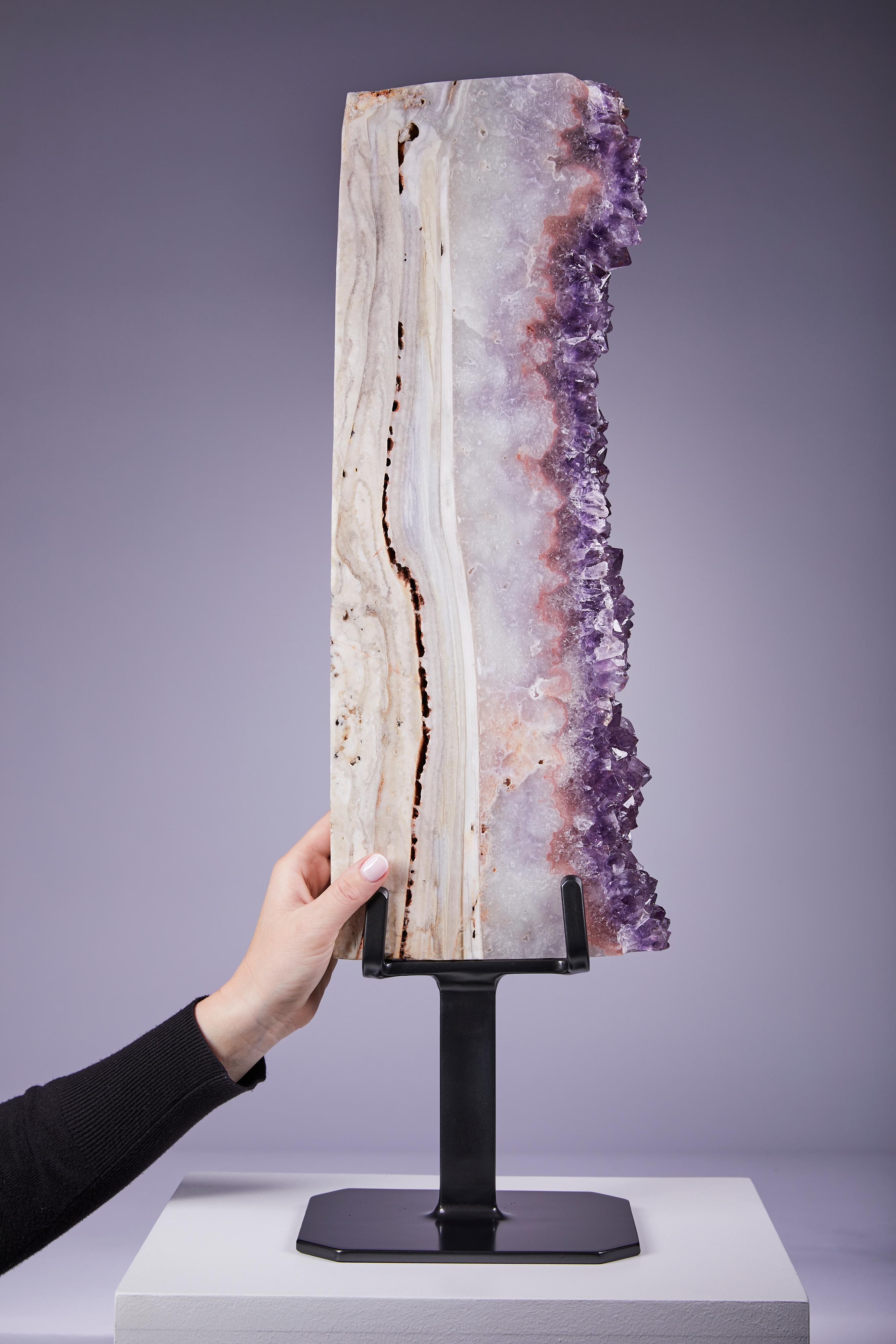 Striking large vertical presentation displaying vibrant purple amethyst bordered by a thick agate layer.  One of a group of four impressive specimens.  Pieces such as this are hard to find owing to the size and shape of the parent geode required to