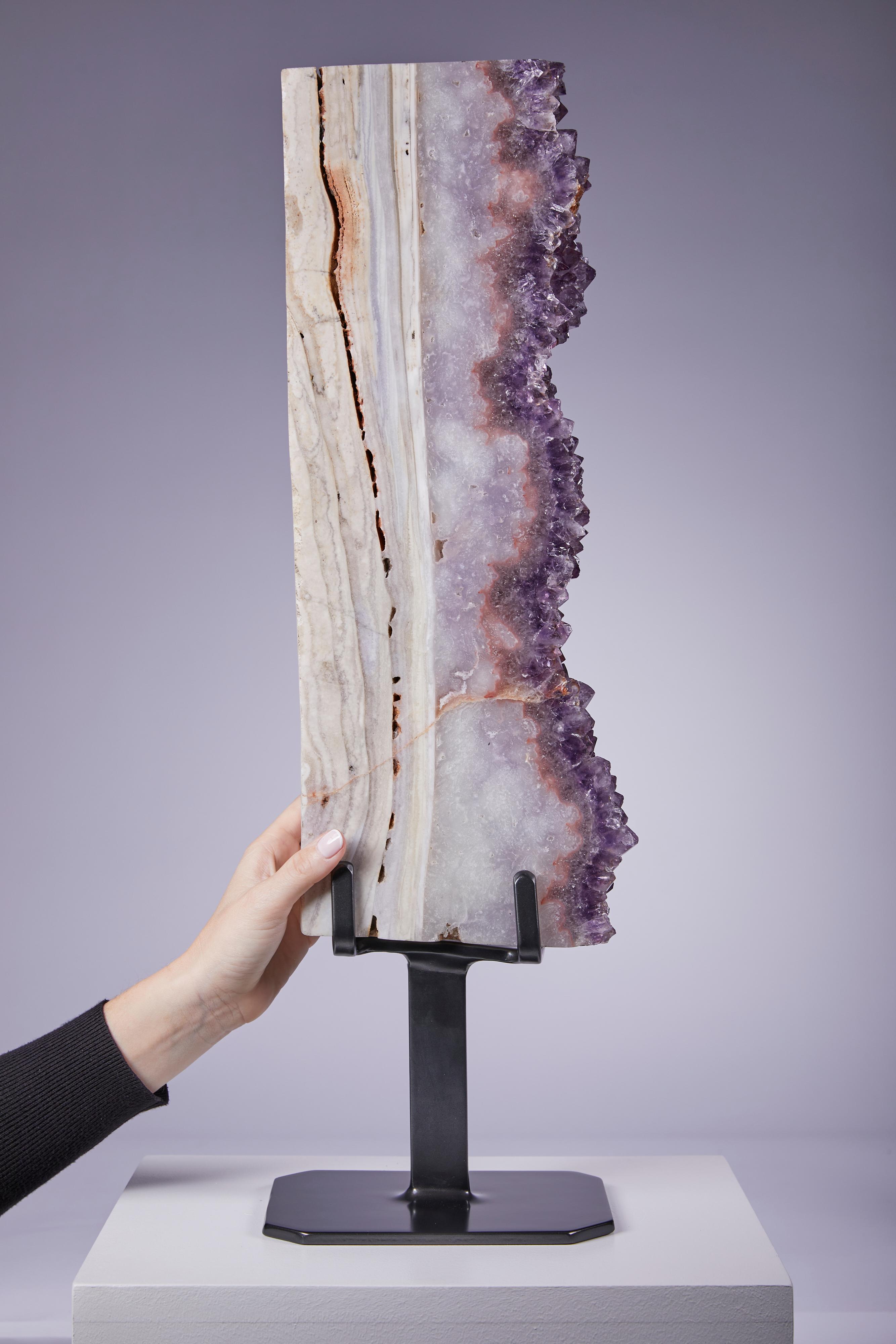 Striking large vertical presentation displaying vibrant purple amethyst bordered by a thick agate layer.  One of a group of four impressive specimens.  Pieces such as this are hard to find owing to the size and shape of the parent geode required to