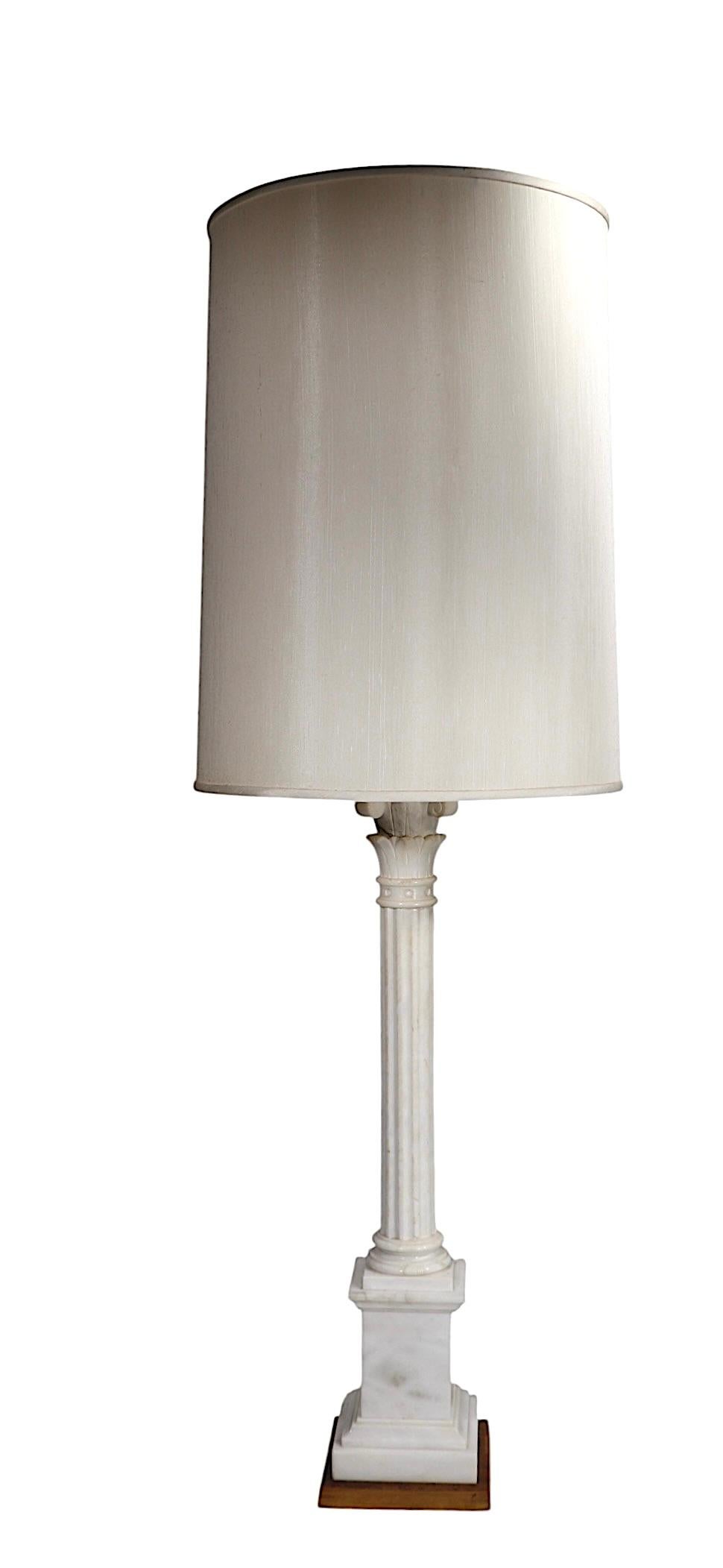 Exceptional oversized table lamp, constructed of hand carved marble,  having a columnar form vertical standard, with a classical capitol, mounted on a square  stepped plinth base. The lamp has two sockets at the top, each of which has its own on/off