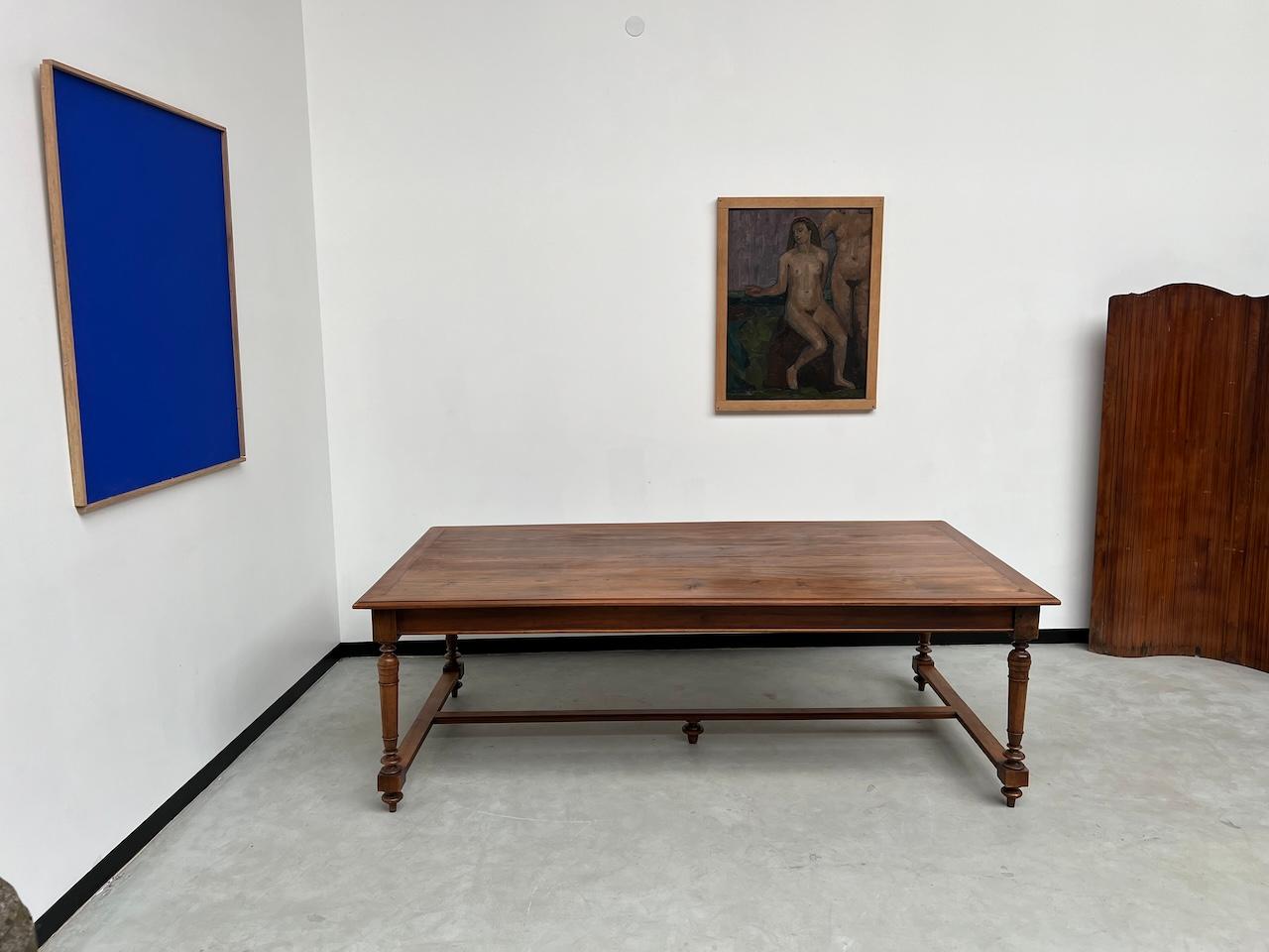La Maison Lecan presenta questo superbo tavolo da conferenza cerato degli anni '50 dalle dimensioni ultra generose per grandi tavolate familiari. L'assemblaggio del tavolo è un bel pezzo di vecchia ebanisteria. Il suo piano in pino ha una patina