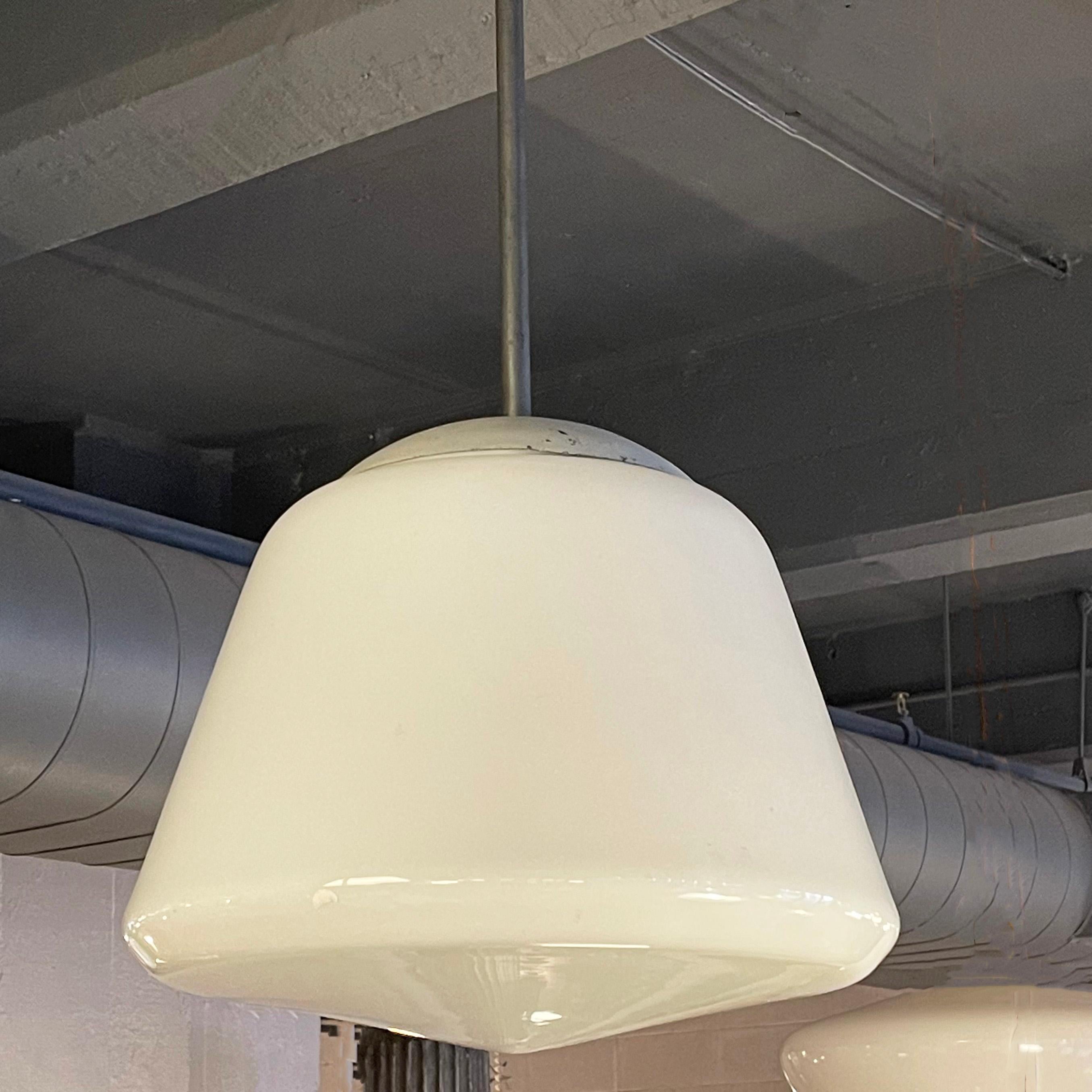 Large, midcentury, library pendant lights circa 1960's feature conical milk glass shades on blackened steel poles. The shades measure 16 inches diameter x 13 inches height. Five pendants are available, sold individually.
