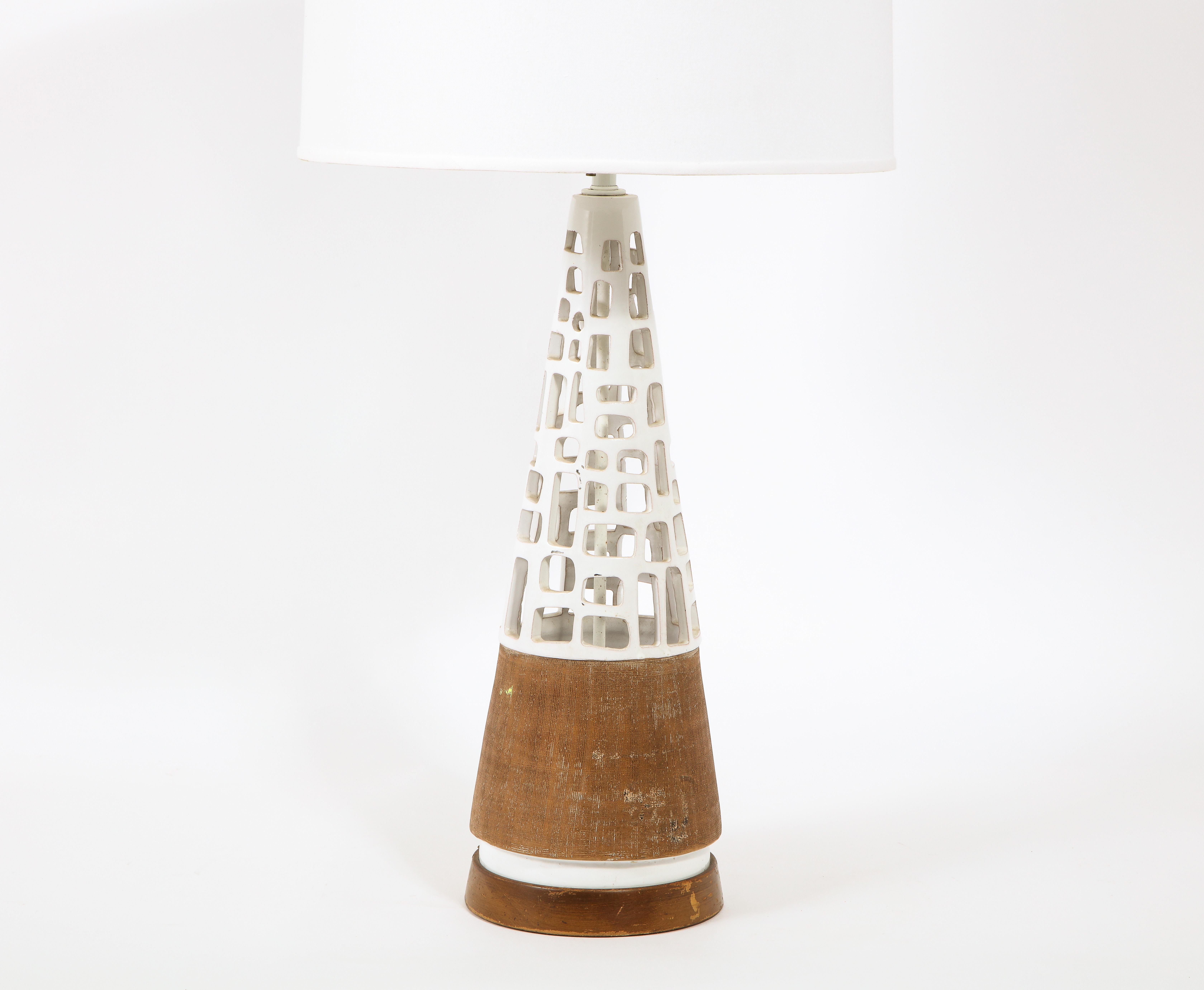 A large pottery table lamp with cut-out walls and dual finishes, part raw pottery, part white glazing, with a matching finial. Rewired

Shade not included.