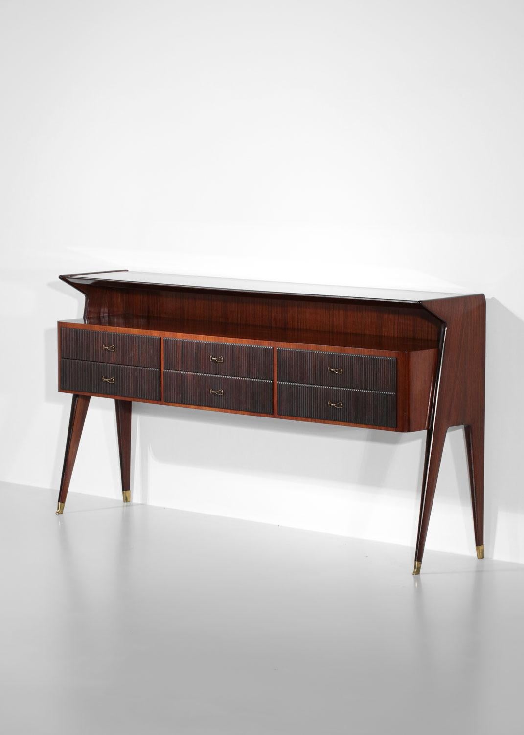 Italian sideboard or console from the 60s by the designer Vittorio Dassi. Structure in solid wood, top in glass slab 1.2 cm thick. This enfilade is composed of six drawers distributed along the furniture, finishing the legs with solid brass. Very